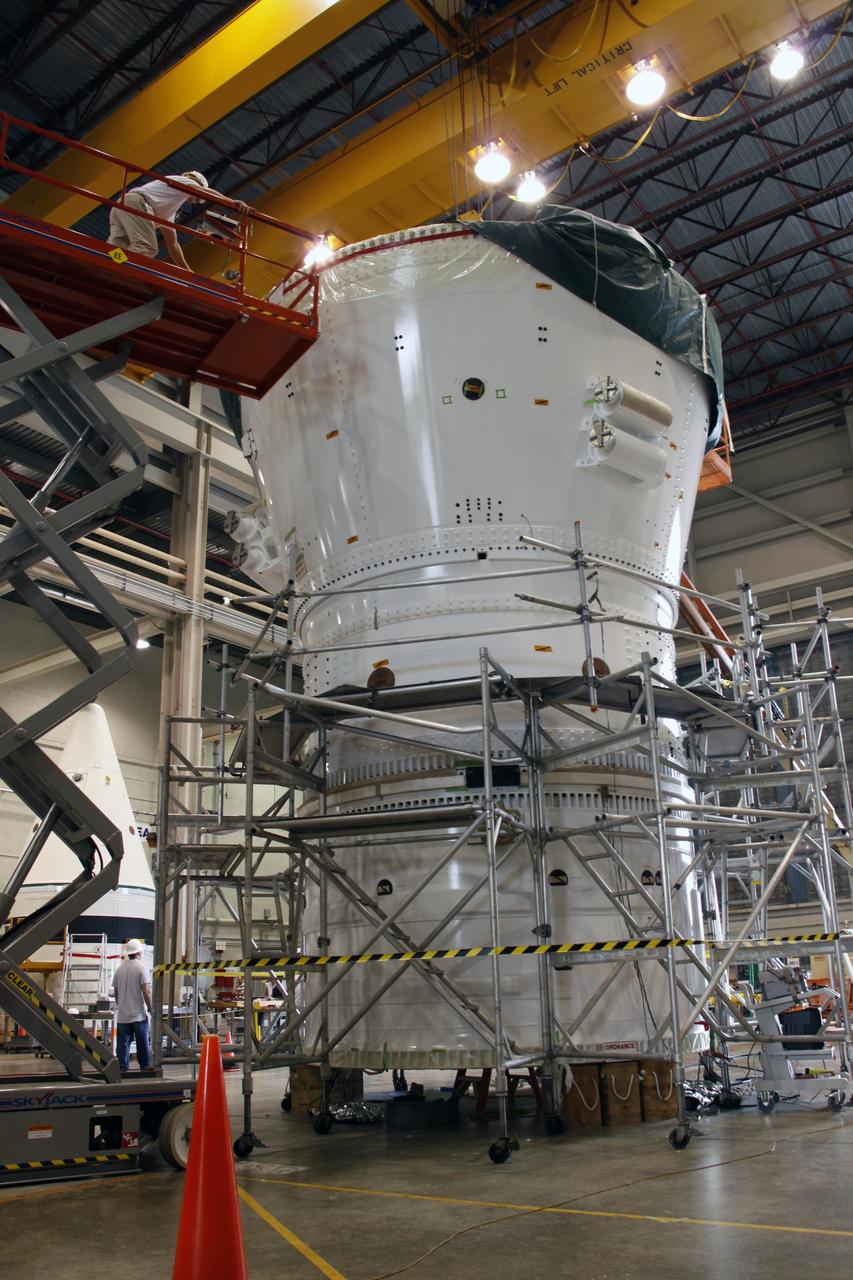 CAPE CANAVERAL, Fla. – In the Assembly and Refurbishment Facility at NASA's Kennedy Space Center in Florida, the Ares I-X frustum is being mated to the forward skirt and forward skirt extension to complete the forward assembly. The assembly will be moved to the Vehicle Assembly Building for stacking operations. Resembling a giant funnel, the frustum's function is to transition the primary flight loads from the rocket's upper stage to the first stage. The frustum is located between the forward skirt extension and the upper stage of the Ares I-X. The launch of Ares I-X is targeted for August 2009. Photo credit: NASA/Troy Cryder