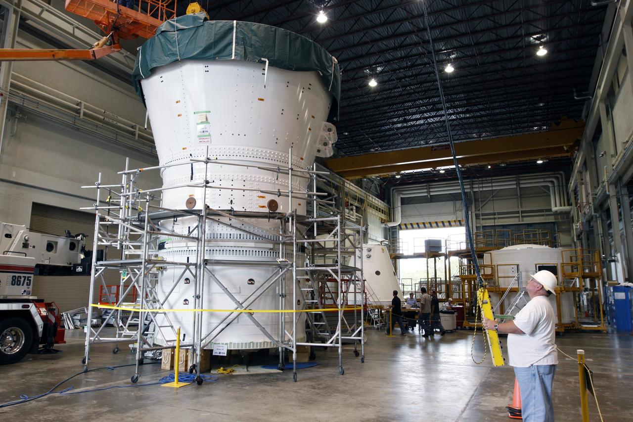 CAPE CANAVERAL, Fla. – In the Assembly and Refurbishment Facility at NASA's Kennedy Space Center in Florida, the Ares I-X frustum is being mated to the forward skirt and forward skirt extension to complete the forward assembly. The assembly will be moved to the Vehicle Assembly Building for stacking operations. Resembling a giant funnel, the frustum's function is to transition the primary flight loads from the rocket's upper stage to the first stage. The frustum is located between the forward skirt extension and the upper stage of the Ares I-X. The launch of Ares I-X is targeted for August 2009. Photo credit: NASA/Troy Cryder