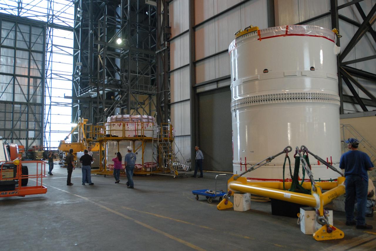 CAPE CANAVERAL, Fla. – In the transfer aisle of the Vehicle Assembly Building at NASA's Kennedy Space Center in Florida, workers prepare to lift the conjoined forward and center segments of the fifth segment simulator for the Ares I-X. The segments will be mated to the simulator’s aft segment, at left. Ares I-X is the test vehicle for the Ares I, a component of the Constellation Program to return men to the moon and beyond. Ares I is the essential core of a safe, reliable, cost-effective space transportation system that eventually will carry crewed missions back to the moon, on to Mars and out into the solar system. The launch of the Ares I-X flight test is targeted for August 2009.  Photo credit: NASA/Jim Grossmann