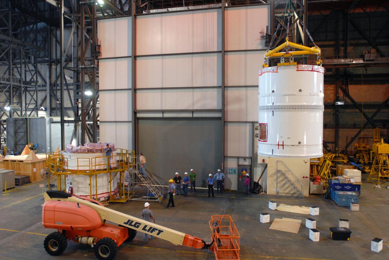 CAPE CANAVERAL, Fla. – In the transfer aisle of the Vehicle Assembly Building at NASA's Kennedy Space Center in Florida, a crane lifts the conjoined forward and center segments of the fifth segment simulator for the Ares I-X.  The segments will be mated to the simulator’s aft segment, at left. Ares I-X is the test vehicle for the Ares I, a component of the Constellation Program to return men to the moon and beyond. Ares I is the essential core of a safe, reliable, cost-effective space transportation system that eventually will carry crewed missions back to the moon, on to Mars and out into the solar system. The launch of the Ares I-X flight test is targeted for August 2009.  Photo credit: NASA/Jim Grossmann