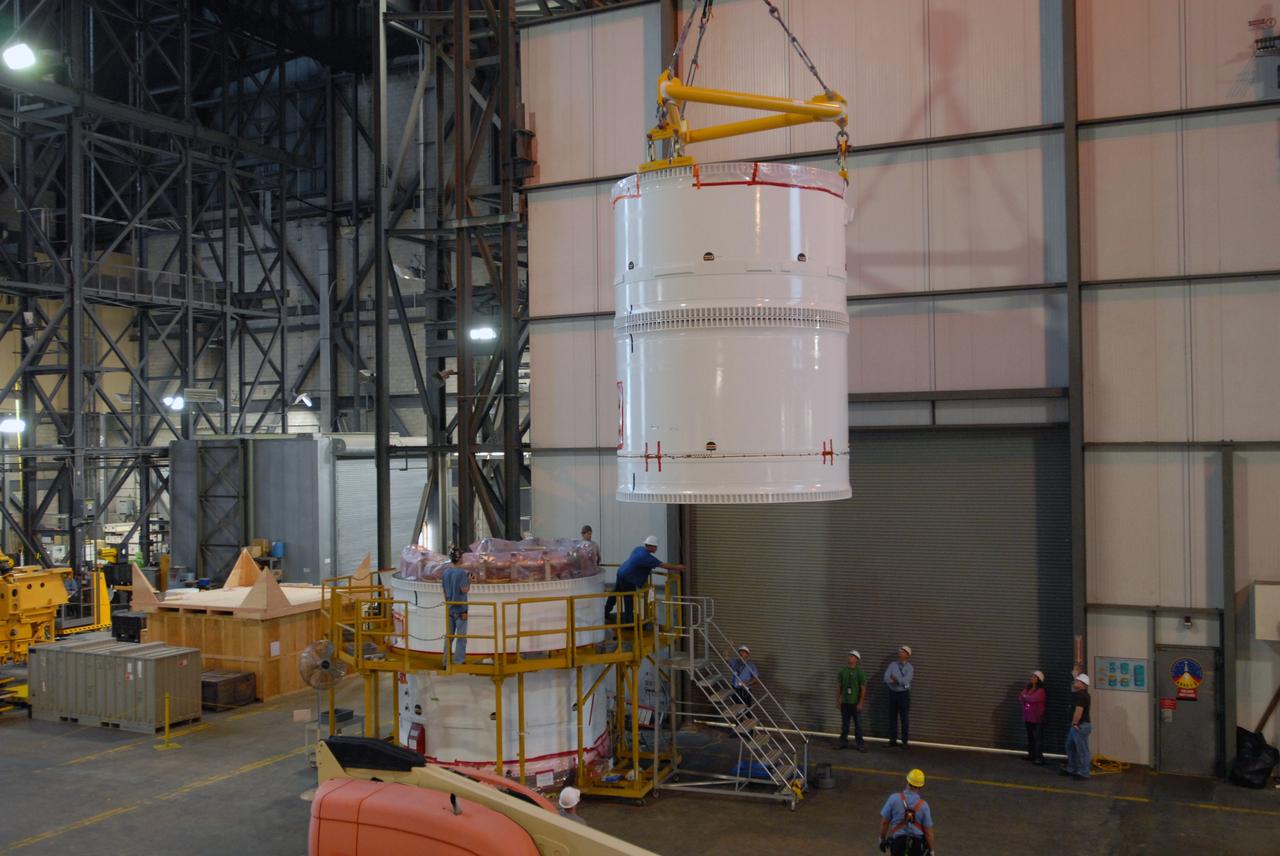 CAPE CANAVERAL, Fla. – In the transfer aisle of the Vehicle Assembly Building at NASA's Kennedy Space Center in Florida, workers monitor the conjoined forward and center segments of the fifth segment simulator for the Ares I-X as a crane lifts them toward the simulator’s aft segment. Ares I-X is the test vehicle for the Ares I, a component of the Constellation Program to return men to the moon and beyond. Ares I is the essential core of a safe, reliable, cost-effective space transportation system that eventually will carry crewed missions back to the moon, on to Mars and out into the solar system. The launch of the Ares I-X flight test is targeted for August 2009.  Photo credit: NASA/Jim Grossmann