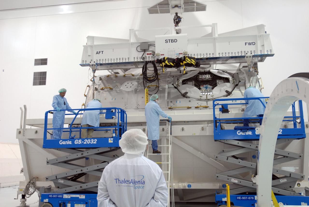CAPE CANAVERAL, Fla. – In the Space Station Processing Facility at NASA's Kennedy Space Center in Florida, workers secure the overhead crane to the Tranquility module, or Node 3, in its shipping container.  The crane will lift and transfer Tranquility to a work stand.  The module will be delivered to the International Space Station on the STS-130 mission. Tranquility will eventually house the life support equipment necessary for the space station's permanent crew of six. It will also accommodate the European Space Agency's Cupola observation module, a seven-window, dome-shaped structure. Tranquility is targeted for launch aboard space shuttle Endeavour in February 2010.  Photo credit: NASA/Jim Grossmann