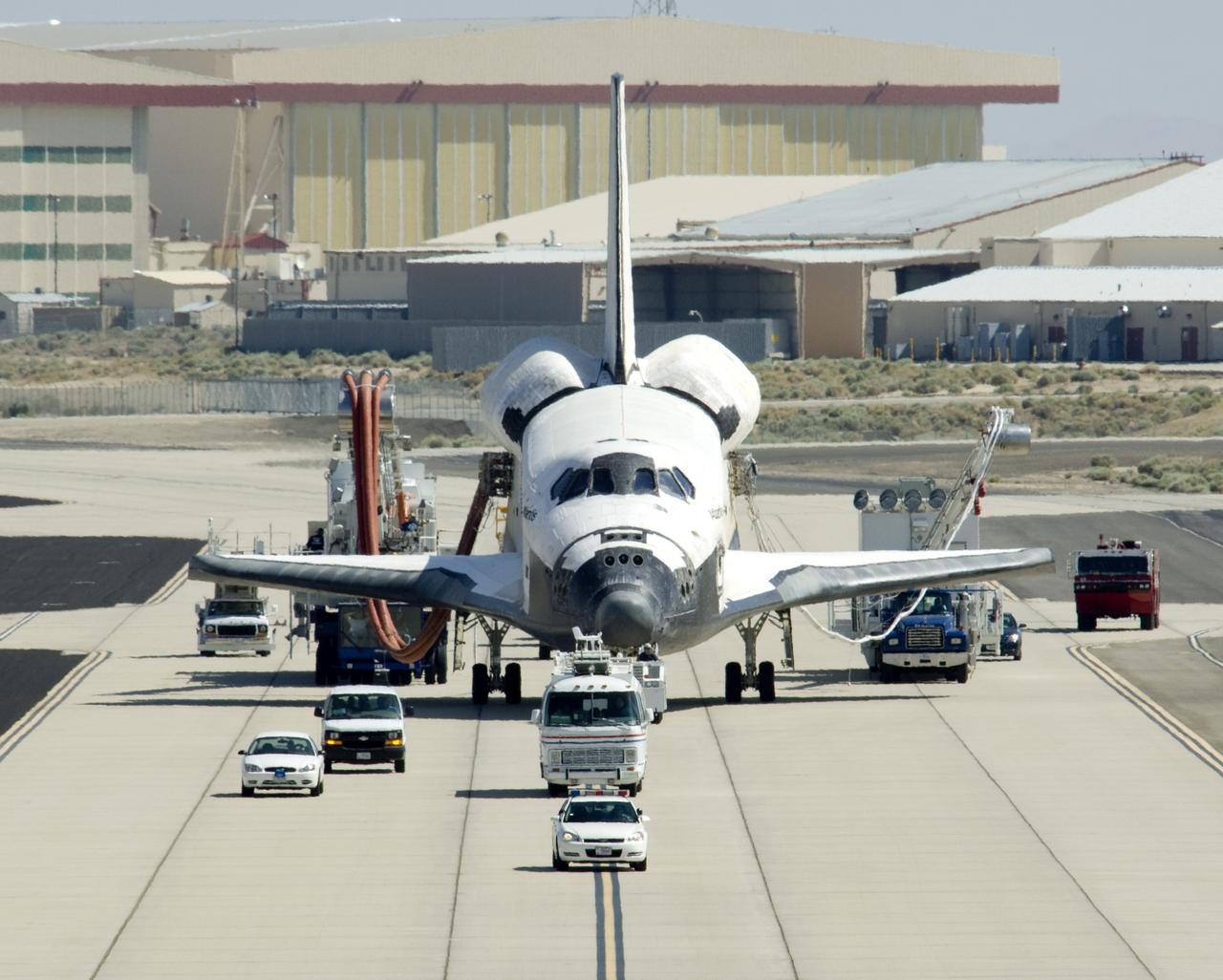 EDWARDS, Calif., -- ED09-0127-12 (EAFB) – Space shuttle Atlantis is towed from the runway at Edwards Air Force Base in California after landing to conclude the 13-day mission to refurbish and upgrade the Hubble Space Telescope. Main gear touchdown was at 11:39:05 a.m. EDT. Nose gear touchdown was at 11:39:15 a.m. Wheel stop was at 11:40:15 a.m., bringing the mission’s elapsed time to 12 days, 21 hours, 37 minutes, 9 seconds. Landing opportunities on May 22, May 23 and May 24 were waved off due to weather concerns at NASA’s Kennedy Space Center in Florida, the shuttle’s primary landing site. Photo credit: NASA/Tony Landis