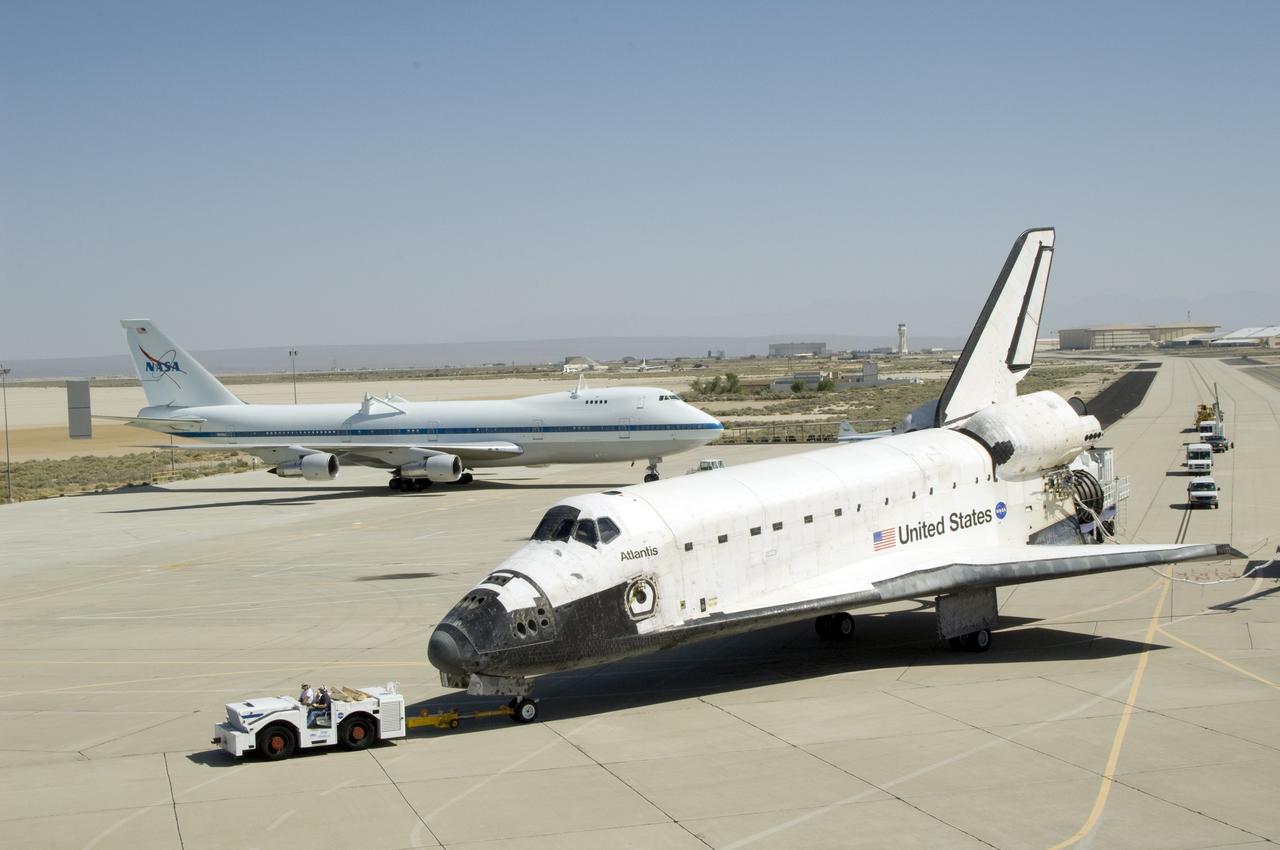 EDWARDS, Calif., -- ED09-0127-13 (EAFB) -- Space shuttle Atlantis is towed from the runway at Edwards Air Force Base in California after landing to conclude the 13-day mission to refurbish and upgrade the Hubble Space Telescope. Main gear touchdown was at 11:39:05 a.m. EDT. Nose gear touchdown was at 11:39:15 a.m. Wheel stop was at 11:40:15 a.m., bringing the mission’s elapsed time to 12 days, 21 hours, 37 minutes, 9 seconds. Landing opportunities on May 22, May 23 and May 24 were waved off due to weather concerns at NASA’s Kennedy Space Center in Florida, the shuttle’s primary landing site. Photo credit: NASA/Tony Landis