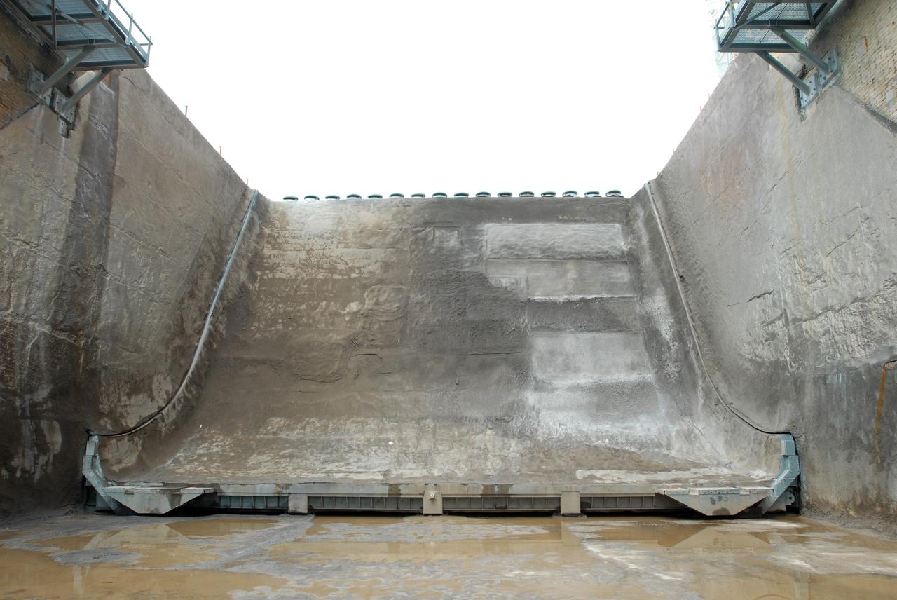 CAPE CANAVERAL, Fla. – A view of the flame trench on Launch Pad 39A at NASA's Kennedy Space Center in Florida where repairs of the Fondue Fyre have been made. After launch of space shuttle Atlantis on the STS-125 mission on May 11, a 25-square-foot area of Fondue Fyre from the north side of the solid rocket booster flame deflector was damaged. Some pneumatic lines (gaseous nitrogen, pressurized air) in the area also were damaged and needed to be repaired. The flame trench channels the flames and smoke exhaust of the shuttle's solid rocket boosters away from the space shuttle during liftoff. Fondue Fyre is a fire-resistant concrete-like material that replaced the original flame trench bricks. It can be sprayed on the surface. Pad 39A will be used for the launch of space shuttle Endeavour on the STS-127 mission targeted for June 13.  Photo credit: NASA/Jim Grossmann