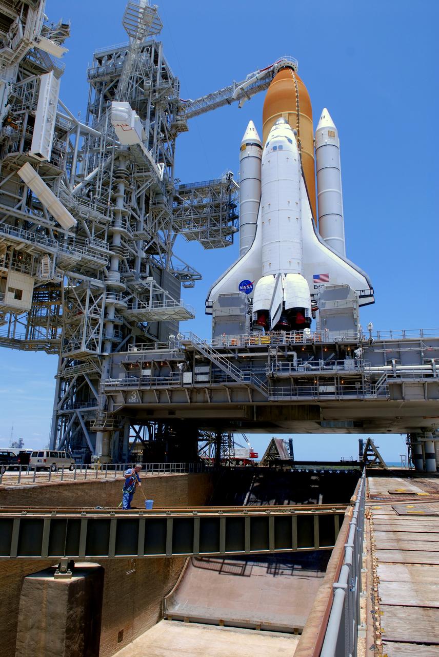 CAPE CANAVERAL, Fla. – On Launch Pad 39A at NASA's Kennedy Space Center in Florida, a worker prepares the rail for the closing of the rotating service structure around space shuttle Endeavour. The RSS provides protected access to the shuttle for changeout and servicing of payloads at the pad. The structure is supported by a rotating bridge that pivots about a vertical axis on the west side of the pad's flame trench. The RSS rotates through 120 degrees (one-third of a circle) on a radius of 160 feet. Support for the outer end of the bridge is provided by two eight-wheel, motor-driven trucks that move along circular twin rails installed flush with the pad surface. The track crosses the flame trench on a permanent bridge. Endeavour is targeted to launch June 13 on its STS-127 mission to the International Space Station. Photo credit: NASA/Tim Jacobs