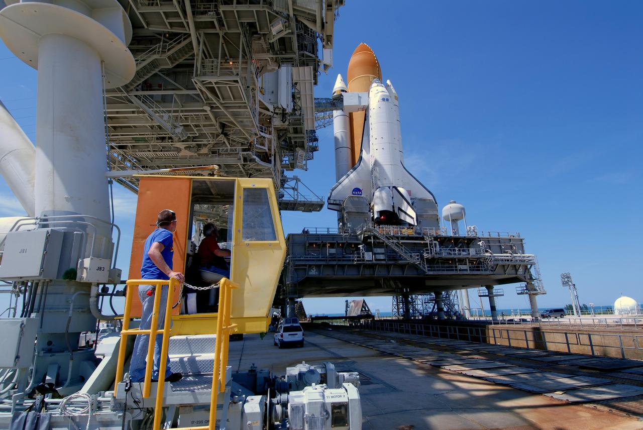 CAPE CANAVERAL, Fla. – On Launch Pad 39A at NASA's Kennedy Space Center in Florida, workers prepare to drive the truck that moves the rotating service structure, or RSS. The RSS will be moved around space shuttle Endeavour.  The RSS provides protected access to the shuttle for changeout and servicing of payloads at the pad. The structure is supported by a rotating bridge that pivots about a vertical axis on the west side of the pad's flame trench. The RSS rotates through 120 degrees (one-third of a circle) on a radius of 160 feet. Support for the outer end of the bridge is provided by two eight-wheel, motor-driven trucks that move along circular twin rails installed flush with the pad surface. The track crosses the flame trench on a permanent bridge. Endeavour is targeted to launch June 13 on its STS-127 mission to the International Space Station. Photo credit: NASA/Tim Jacobs