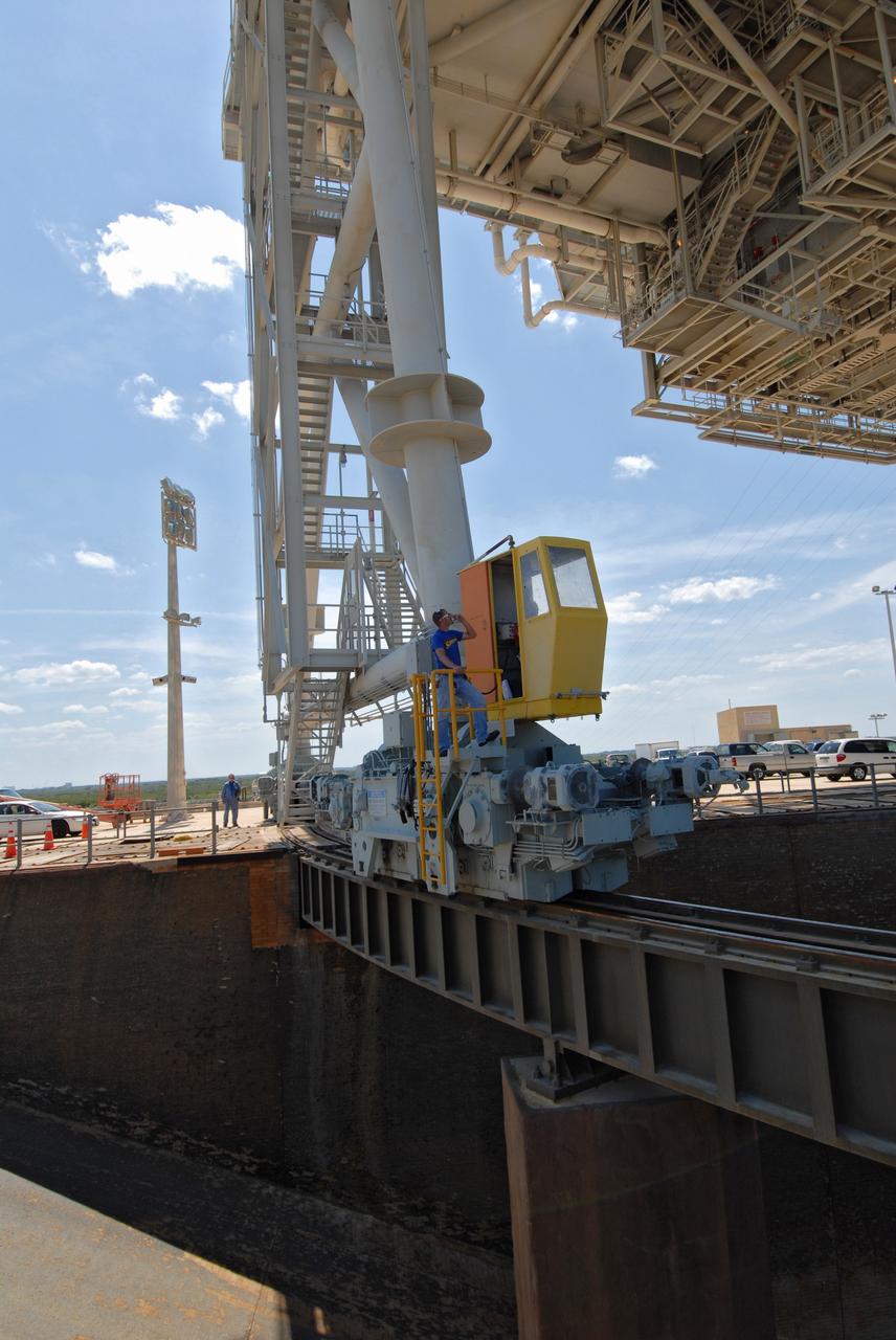 CAPE CANAVERAL, Fla. – On Launch Pad 39A at NASA's Kennedy Space Center in Florida, workers begin closing the rotating service structure, or RSS, around space shuttle Endeavour.  The RSS provides protected access to the shuttle for changeout and servicing of payloads at the pad. The structure is supported by a rotating bridge that pivots about a vertical axis on the west side of the pad's flame trench. The RSS rotates through 120 degrees (one-third of a circle) on a radius of 160 feet. Support for the outer end of the bridge is provided by two eight-wheel, motor-driven trucks that move along circular twin rails installed flush with the pad surface. The track crosses the flame trench on a permanent bridge. Endeavour is targeted to launch June 13 on its STS-127 mission to the International Space Station. Photo credit: NASA/Tim Jacobs