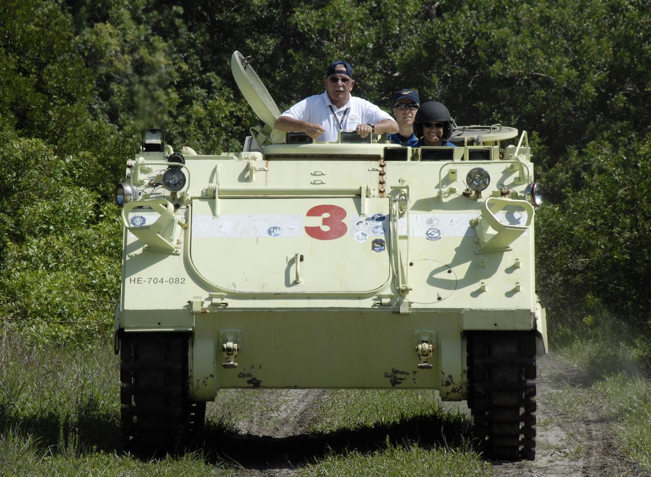 CAPE CANAVERAL, Fla. – STS-127 Mission Specialist Julie Payette takes her turn practice driving the M-113 armored personnel carrier, which is part of the training on emergency egress procedures. Payette represents the Canadian Space Agency. Behind her is Pilot Doug Hurley. The crew members of space shuttle Endeavour's STS-127 mission are taking turns driving the M-113.  An M-113 will be available to transport the crew to safety in the event of a contingency on the pad before their launch. The crew is at NASA's Kennedy Space Center for a launch dress rehearsal called the terminal countdown demonstration test, or TCDT, which includes the emergency egress training and equipment familiarization.  The STS-127 mission is the final of three flights dedicated to the assembly of the Japanese Kibo laboratory complex.  Endeavour's launch is targeted for June 13.  Photo credit: NASA/Kim Shiflett