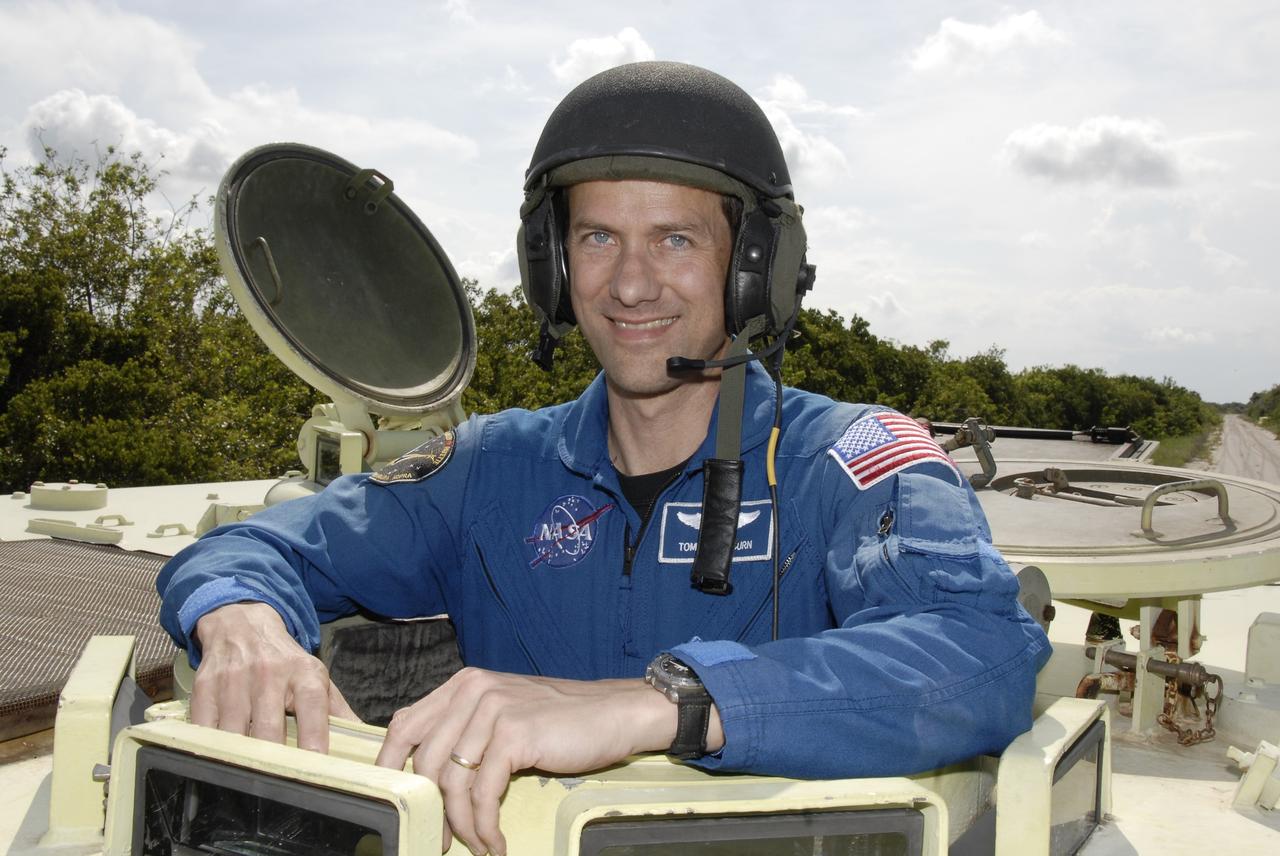 CAPE CANAVERAL, Fla. – STS-127 Mission Specialist Tom Marshburn smiles after successfully driving the M-113 armored personnel carrier, which is part of the training on emergency egress procedures. The crew members of space shuttle Endeavour's STS-127 mission are taking turns driving the M-113.  An M-113 will be available to transport the crew to safety in the event of a contingency on the pad before their launch. The crew is at NASA's Kennedy Space Center for a launch dress rehearsal called the terminal countdown demonstration test, or TCDT, which includes the emergency egress training and equipment familiarization.  The STS-127 mission is the final of three flights dedicated to the assembly of the Japanese Kibo laboratory complex.  Endeavour's launch is targeted for June 13.  Photo credit: NASA/Kim Shiflett