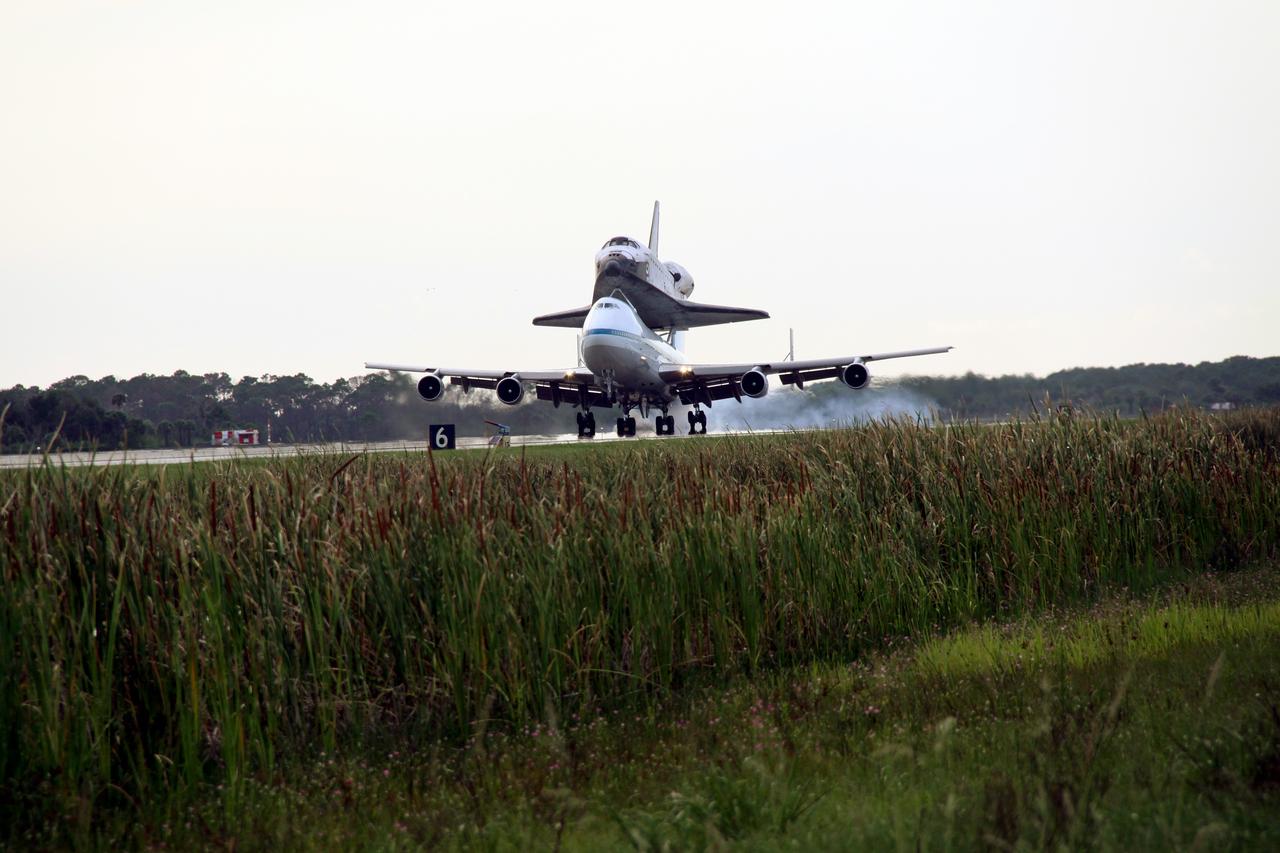 CAPE CANAVERAL, Fla. – After a two-day trip from California, the Shuttle Carrier Aircraft, or SCA, and its piggyback passenger space shuttle Atlantis lands on NASA Kennedy Space Center's Shuttle Landing Facility runway 15. The SCA is a modified Boeing 747 jetliner. Visible on Atlantis is the tail cone, which protects the aft engine area and provides a more efficient aeronautical dimension during flight. Atlantis returned from California atop the SCA after its May 24 landing at Edwards Air Force Base, concluding mission STS-125. The ferry flight from Edwards Air Force Base began June 1. Touchdown at Kennedy was at 6:53 p.m. EDT. Photo credit: NASA/Jack Pfaller