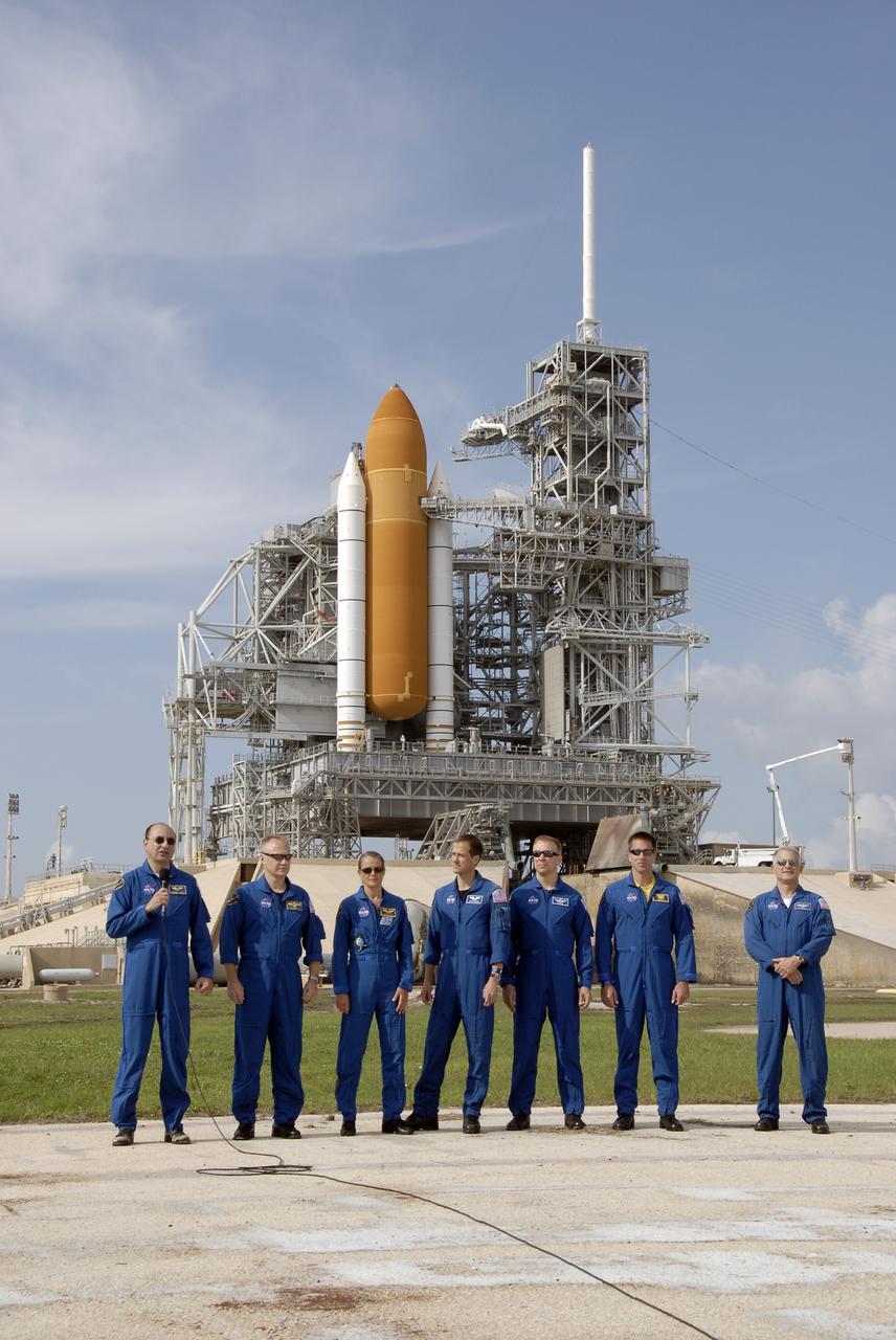 CAPE CANAVERAL, Fla. –  STS-127 crew members gather at NASA Kennedy Space Center's Launch Pad 39A for a question-and-answer session with the media. At left is Commander Mark Polansky, introducing the other astronauts, who are, from left, Pilot Doug Hurley and Mission Specialists Julie Payette, Tom Marshburn, Tim Kopra, Chris Cassidy and Dave Wolf.  Payette represents the Canadian Space Agency. In the background is the fixed service structure with the solid rocket boosters and external fuel tank attached to space shuttle Endeavour.  The crew is at Kennedy for a launch dress rehearsal called the terminal countdown demonstration test, or TCDT, which includes emergency egress training and equipment familiarization.  Space shuttle Endeavour's STS-127 mission is the final of three flights dedicated to the assembly of the Japanese Kibo laboratory complex on the International Space Station.  Endeavour's launch is targeted for June 13.    Photo credit: NASA/Kim Shiflett