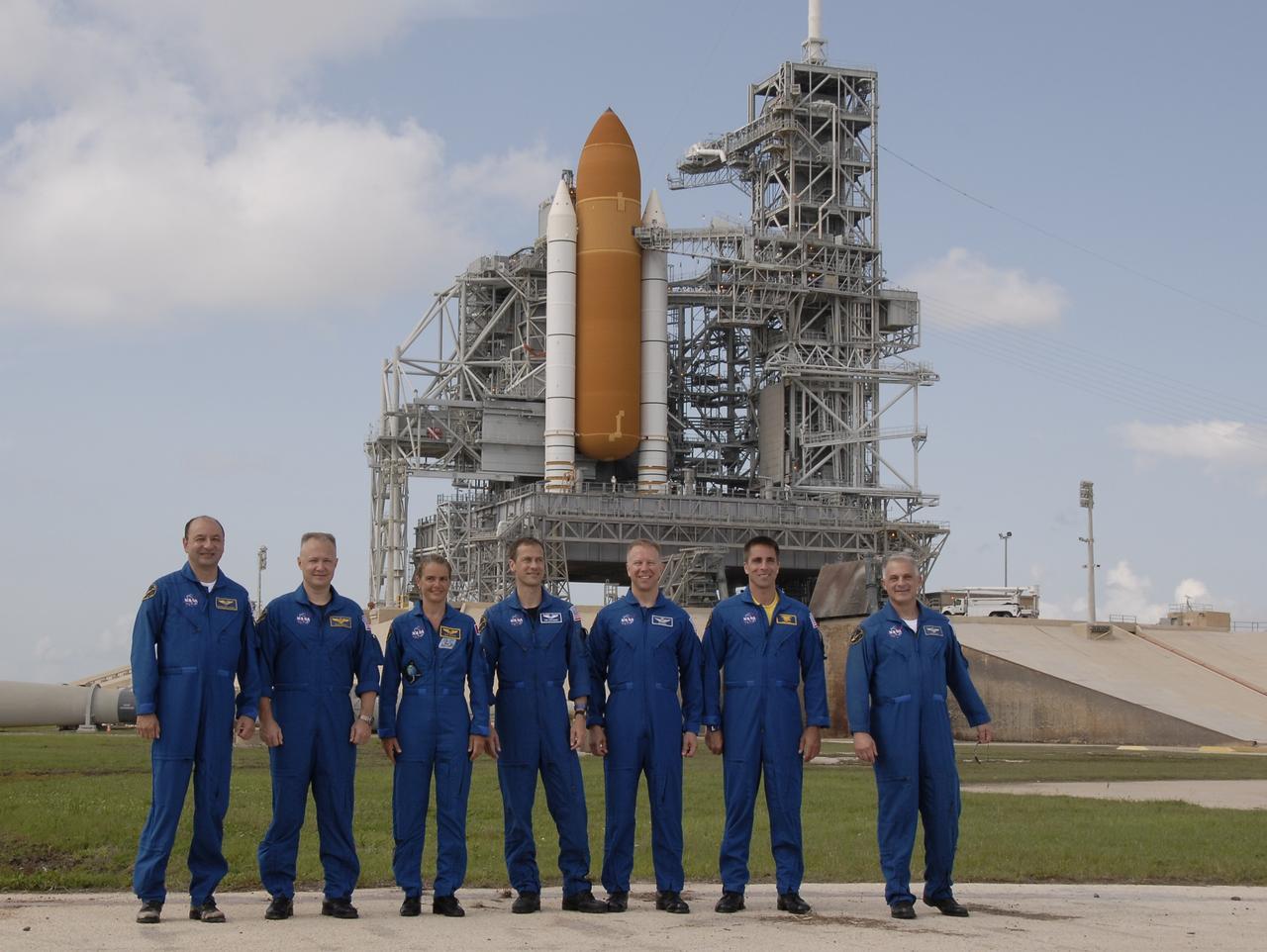 CAPE CANAVERAL, Fla. –  The STS-127 crew members stand for a final photograph after a question-and-answer session with the media at NASA Kennedy Space Center's Launch Pad 39A.  From left are Commander Mark Polansky, Pilot Doug Hurley and Mission Specialists Julie Payette, Tom Marshburn , Tim Kopra, Christopher Cassidy and Dave Wolf.  Payette represents the Canadian Space Agency.  The crew is at Kennedy for a launch dress rehearsal called the terminal countdown demonstration test, or TCDT, which includes emergency egress training and equipment familiarization.  Space shuttle Endeavour's STS-127 mission is the final of three flights dedicated to the assembly of the Japanese Kibo laboratory complex on the International Space Station.  Endeavour's launch is targeted for June 13.    Photo credit: NASA/Kim Shiflett