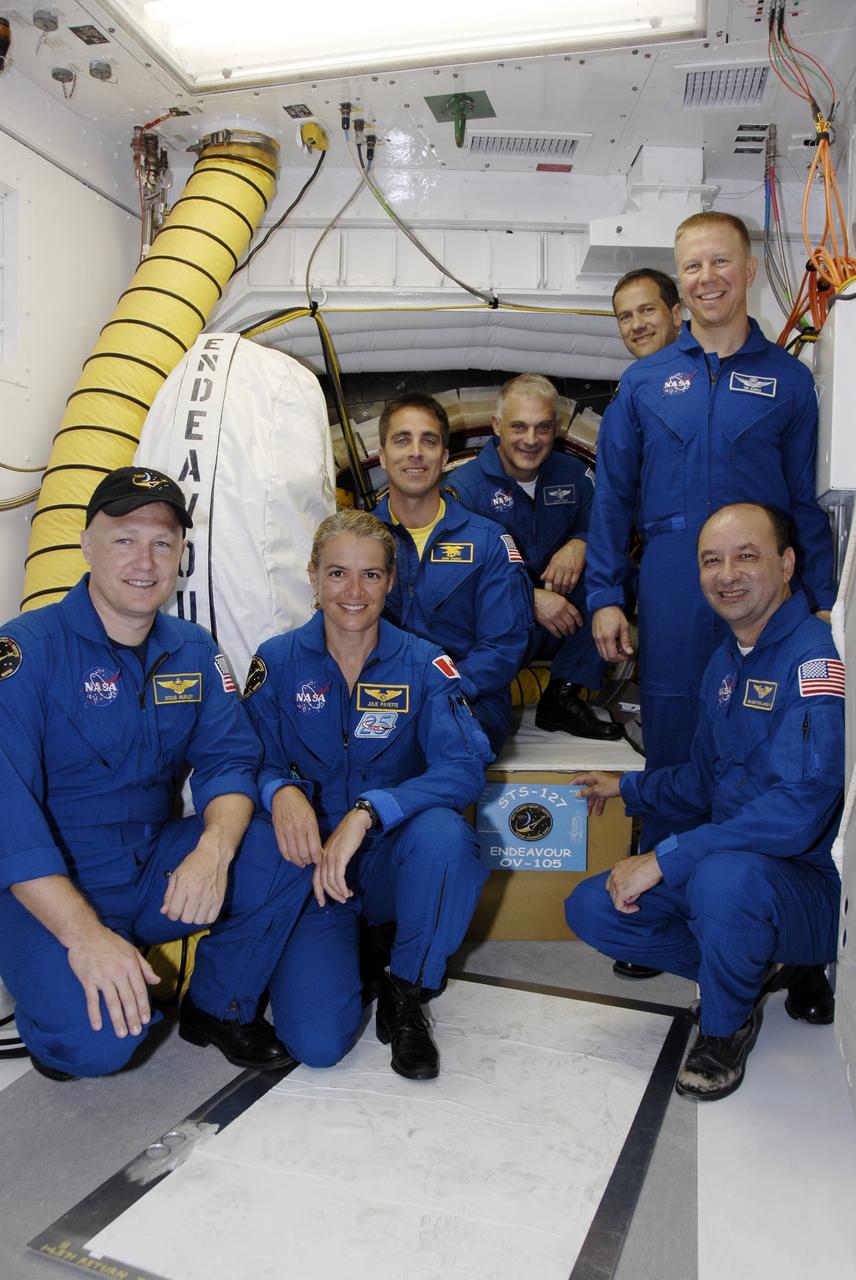 CAPE CANAVERAL, Fla. –  On Launch Pad 39A at NASA's Kennedy Space Center in Florida, STS-127 crew members gather near space shuttle Endeavour's hatch to place the mission plaque before launch.  Clockwise from left are Pilot Doug Hurley, Mission Specialists Julie Payette, Christopher Cassidy, Dave Wolf, Tom Marshburn and Tim Kopra and Commander Mark Polansky. Payette represents the Canadian Space Agency. The crew is at Kennedy for a launch dress rehearsal called the terminal countdown demonstration test, or TCDT, which includes emergency exit training and equipment familiarization.  Endeavour's STS-127 mission is the final of three flights dedicated to the assembly of the Japanese Kibo laboratory complex on the International Space Station.  Endeavour's launch is targeted for June 13.   Photo credit: NASA/Kim Shiflett