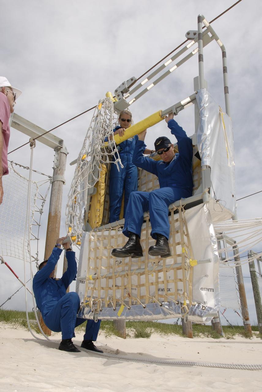 CAPE CANAVERAL, Fla. –  At the slidewire basket landing area near Launch Pad 39A at NASA's Kennedy Space Center in Florida, STS-127 crew members practice getting out of a basket.  The baskets are used for emergency exits from the pad.  Inside the basket are Mission Specialists Julie Payette and Tim Kopra. The crew is at Kennedy for a launch dress rehearsal called the terminal countdown demonstration test, or TCDT, which includes emergency exit training and equipment familiarization.  Endeavour's STS-127 mission is the final of three flights dedicated to the assembly of the Japanese Kibo laboratory complex on the International Space Station.  Endeavour's launch is targeted for June 13.   Photo credit: NASA/Kim Shiflett