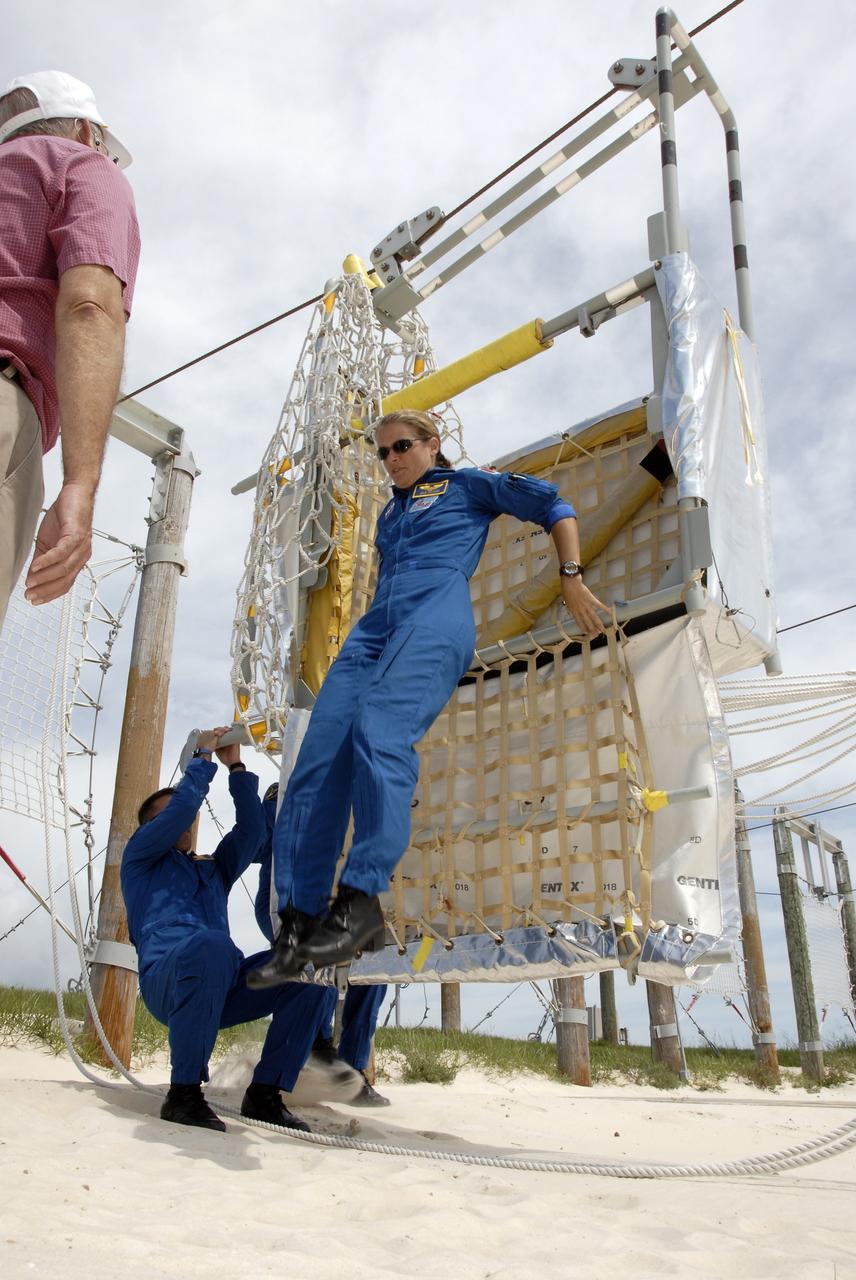 CAPE CANAVERAL, Fla. –  At the slidewire basket landing area near Launch Pad 39A at NASA's Kennedy Space Center in Florida, STS-127 Mission Specialist Julie Payette practices getting out of a basket, which are used for emergency exits from the pad.  The crew is at Kennedy for a launch dress rehearsal called the terminal countdown demonstration test, or TCDT, which includes emergency exit training and equipment familiarization.  Endeavour's STS-127 mission is the final of three flights dedicated to the assembly of the Japanese Kibo laboratory complex on the International Space Station.  Endeavour's launch is targeted for June 13.   Photo credit: NASA/Kim Shiflett