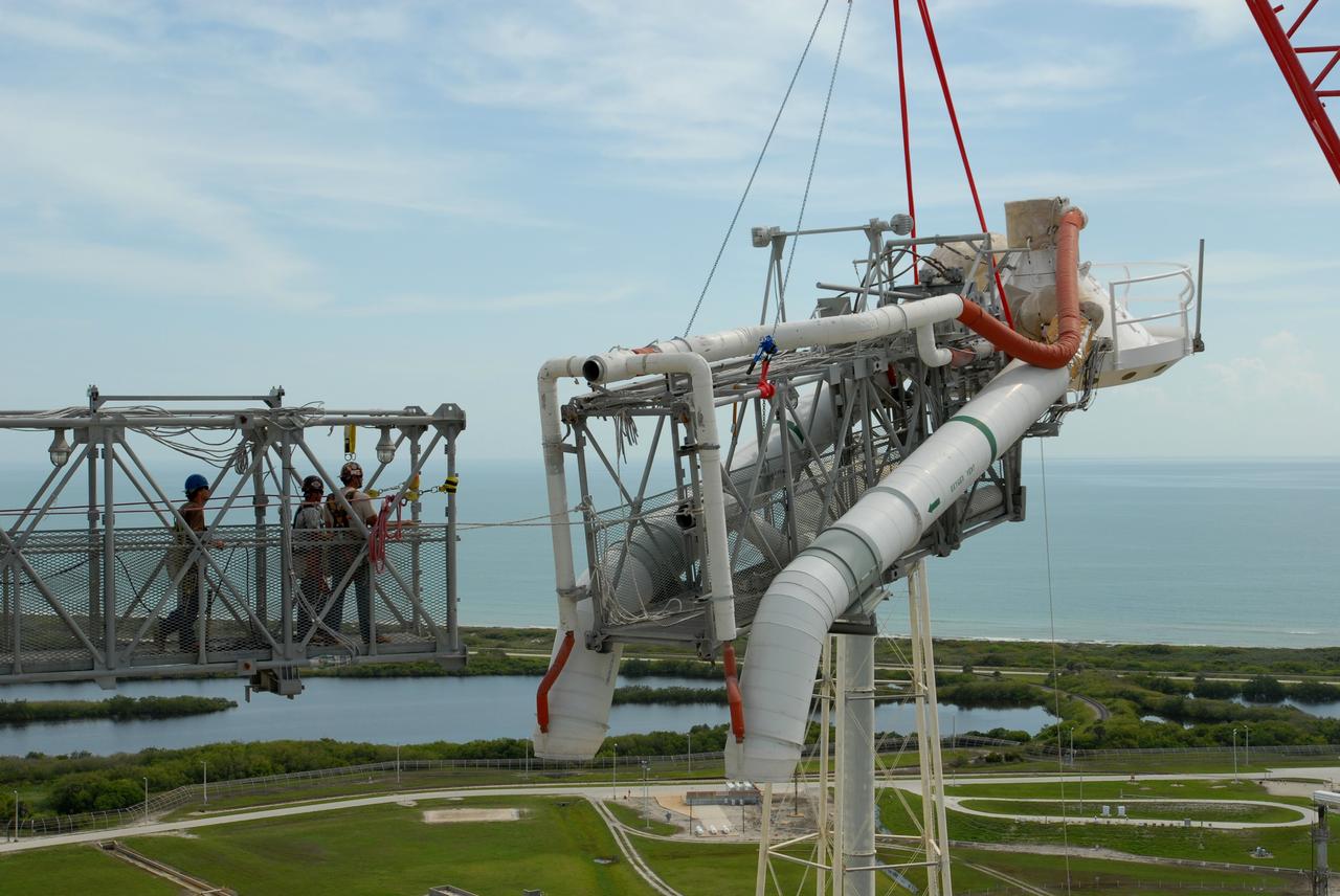 CAPE CANAVERAL, Fla. – On Launch Pad 39B at NASA's Kennedy Space Center in Florida, a crane removes the oxygen vent hood, called the "beanie cap," and the gaseous oxygen vent arm from the fixed service structure. A portion of the service structure is being removed for the pad's conversion as launch site for the Constellation Program's Ares I-X. The launch of the Ares I-X flight test is targeted for August 2009. Photo credit: NASA/Jim Grossmann