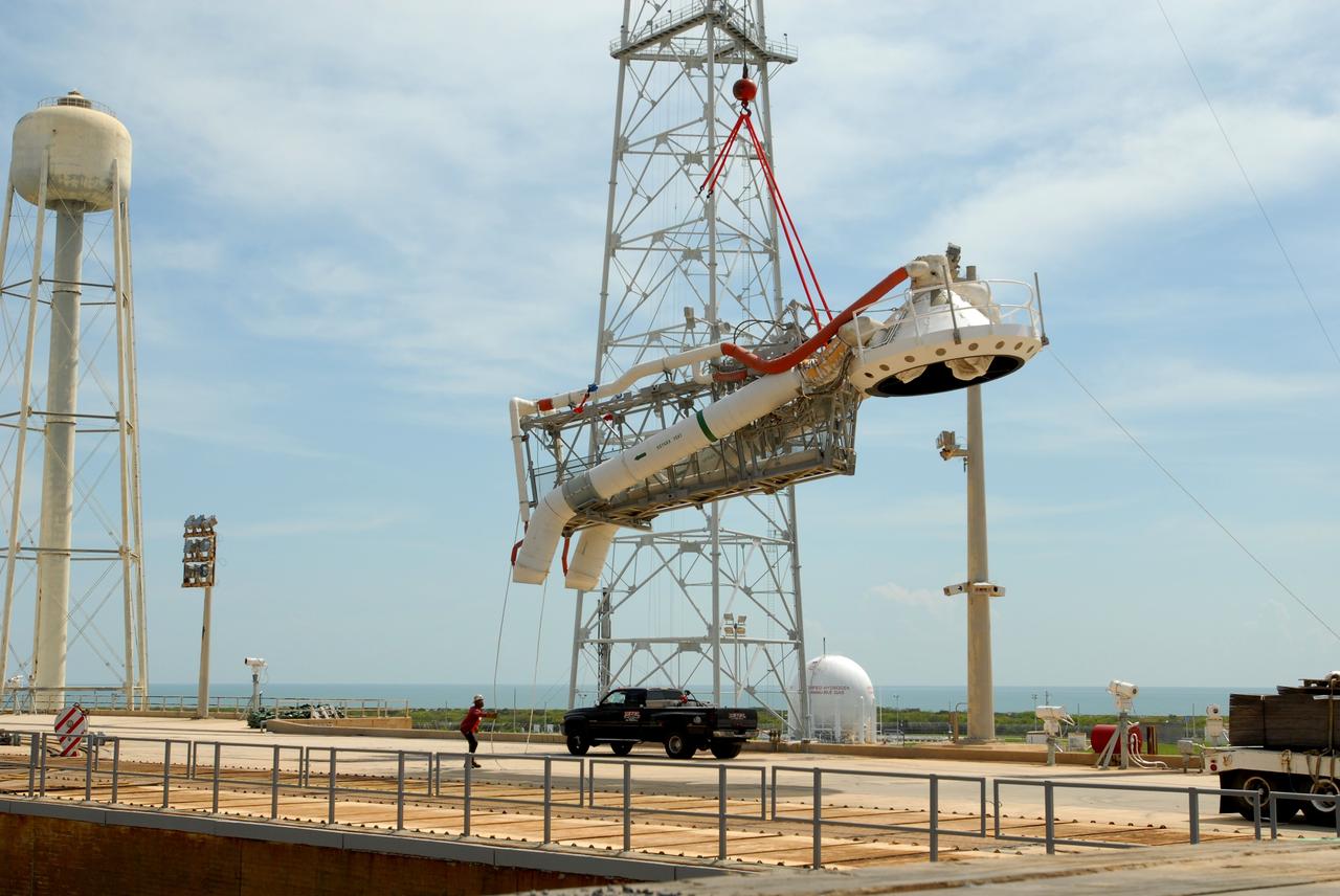 CAPE CANAVERAL, Fla. – On Launch Pad 39B at NASA's Kennedy Space Center in Florida, a crane lowers the oxygen vent hood, called the "beanie cap," and the gaseous oxygen vent arm onto the pad. A portion of the service structure is being removed for the pad's conversion as launch site for the Constellation Program's Ares I-X. The launch of the Ares I-X flight test is targeted for August 2009. Photo credit: NASA/Jim Grossmann