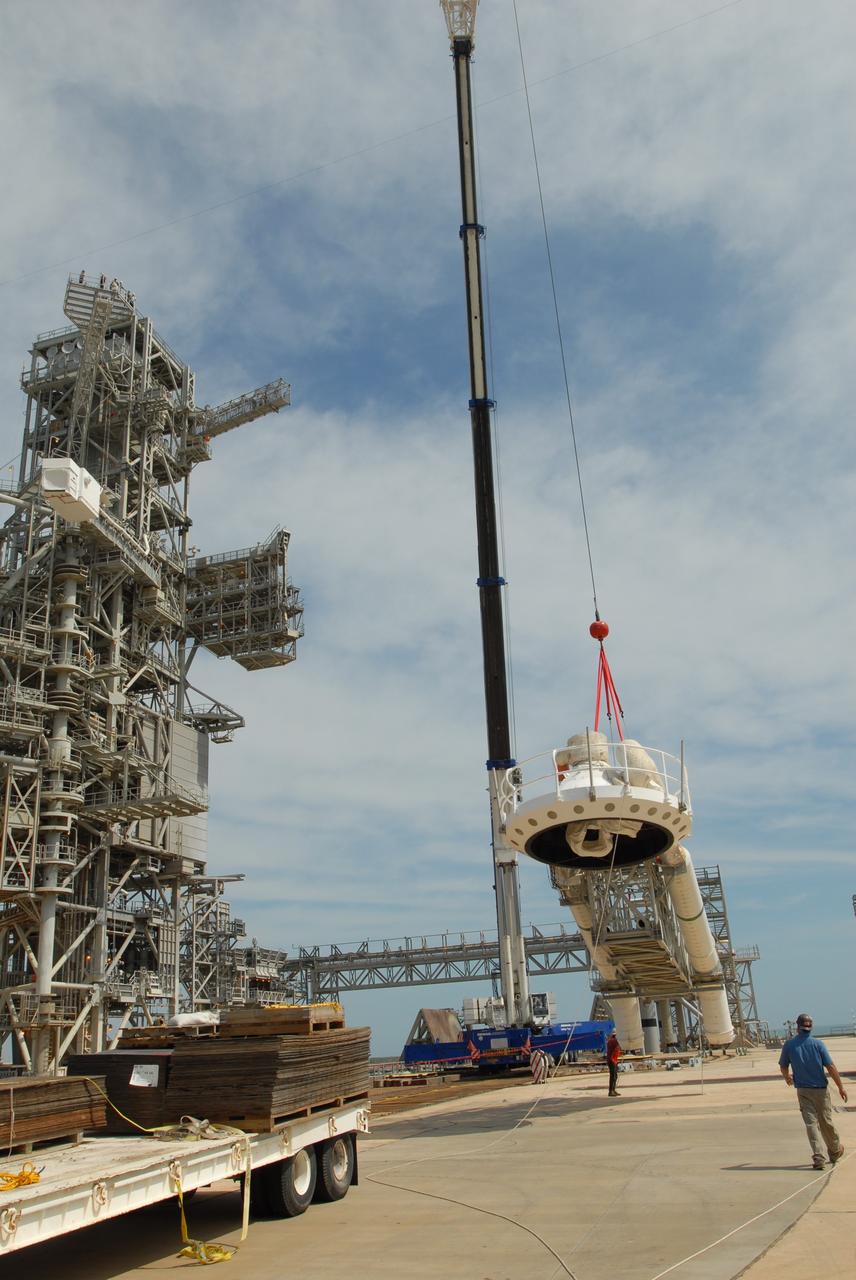 CAPE CANAVERAL, Fla. – On Launch Pad 39B at NASA's Kennedy Space Center in Florida, a crane lowers the oxygen vent hood, called the "beanie cap," and the gaseous oxygen vent arm onto the pad. A portion of the service structure is being removed for the pad's conversion as launch site for the Constellation Program's Ares I-X. The launch of the Ares I-X flight test is targeted for August 2009. Photo credit: NASA/Jim Grossmann