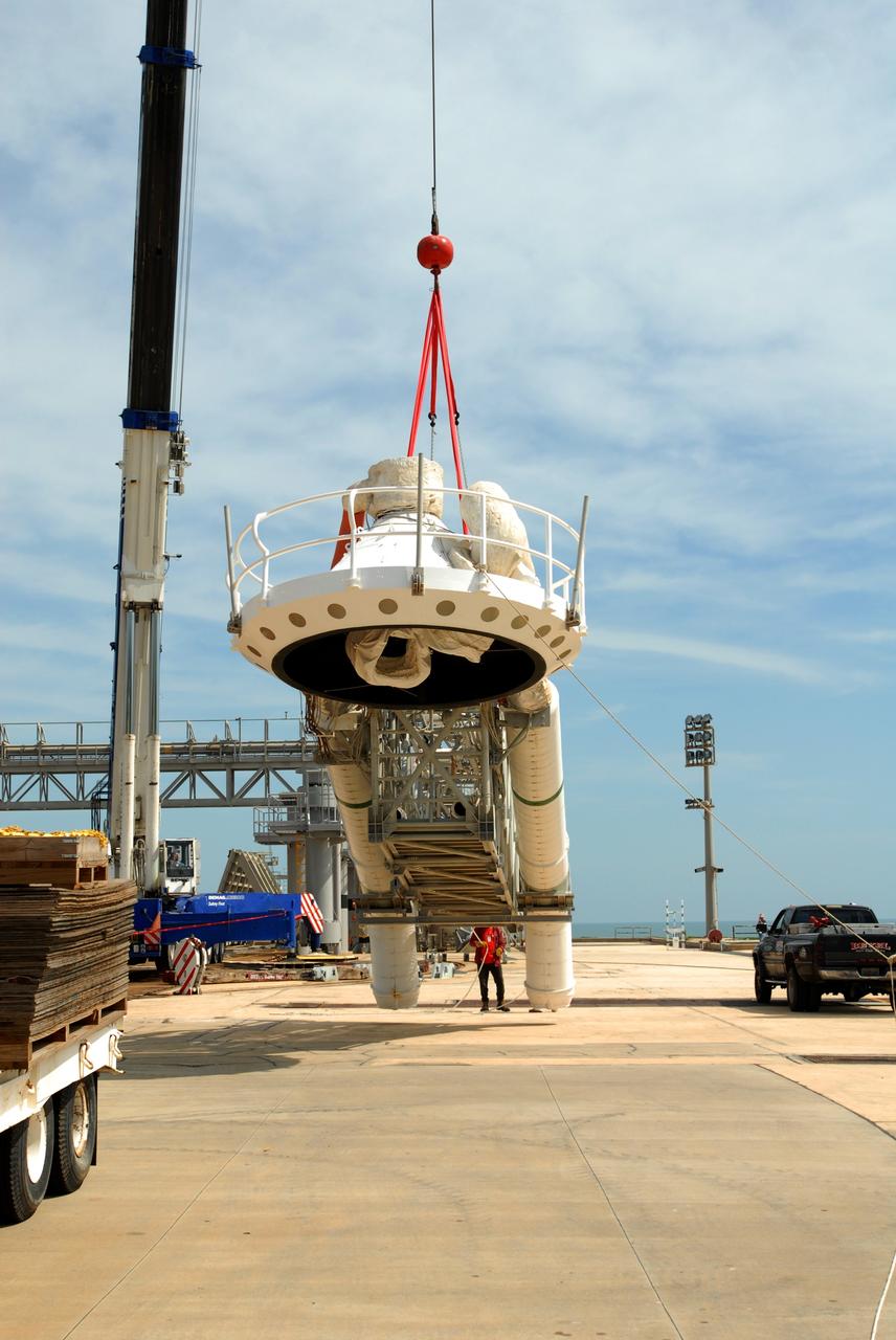 CAPE CANAVERAL, Fla. – On Launch Pad 39B at NASA's Kennedy Space Center in Florida, a crane lowers the oxygen vent hood, called the "beanie cap," and the gaseous oxygen vent arm onto the pad. A portion of the service structure is being removed for the pad's conversion as launch site for the Constellation Program's Ares I-X. The launch of the Ares I-X flight test is targeted for August 2009. Photo credit: NASA/Jim Grossmann
