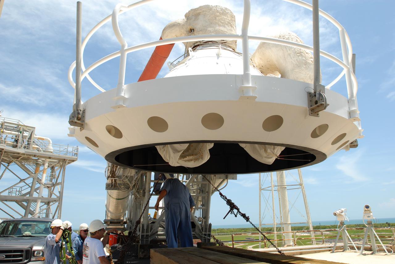 CAPE CANAVERAL, Fla. – At NASA's Kennedy Space Center in Florida, workers check the "beanie cap" and the gaseous oxygen vent arm removed from Launch Pad 39B's fixed service structure before they are taken away on the transporter. A portion of the service structure is being removed for the pad's conversion as launch site for the Constellation Program's Ares I-X. The launch of the Ares I-X flight test is targeted for August 2009. Photo credit: NASA/Jim Grossmann