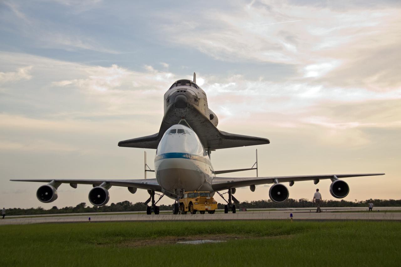 CAPE CANAVERAL, Fla. – Against a setting sun, space shuttle Atlantis, atop a Shuttle Carrier Aircraft, or SCA, is towed from the runway at NASA's Kennedy Space Center in Florida. The SCA is a modified Boeing 747 jetliner. Atlantis returned from California atop the SCA after its May 24 landing at Edwards Air Force Base, concluding mission STS-125. The ferry flight from Edwards Air Force Base began June 1. Atlantis' next assignment is the STS-129 mission, targeted to launch in November 2009. Photo credit: NASA/Jack Pfaller