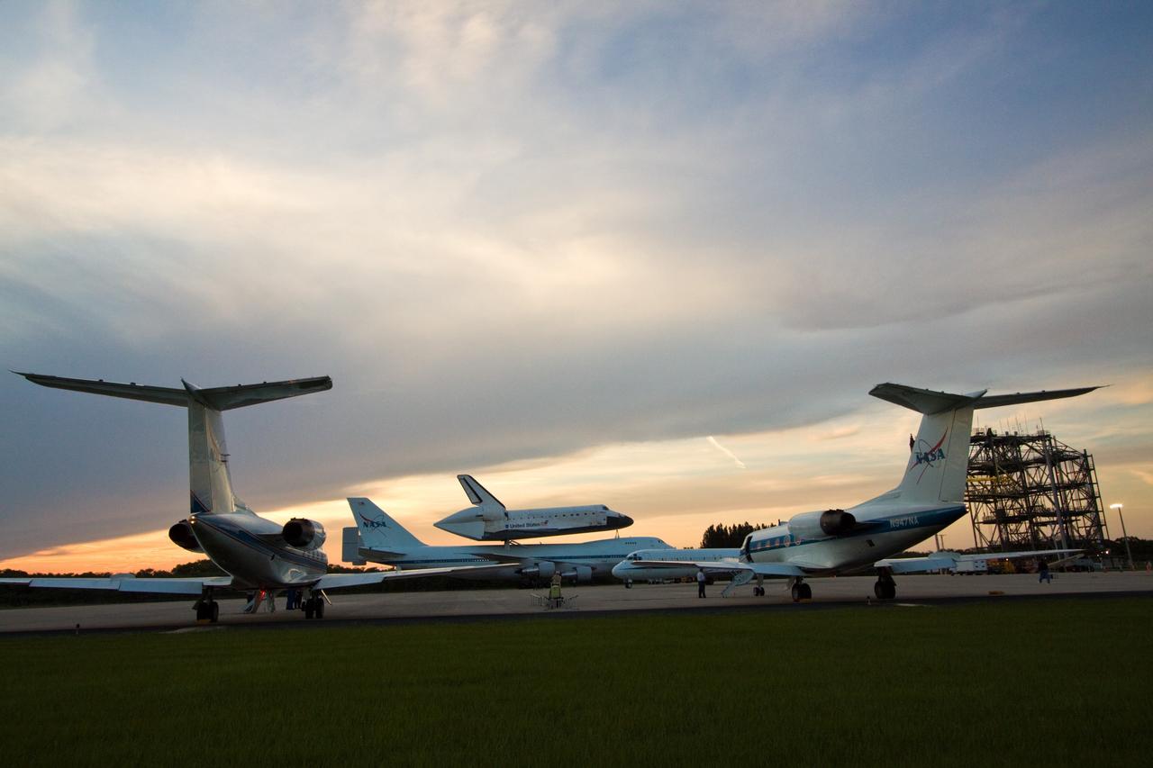 CAPE CANAVERAL, Fla. – Under a dimming sky, space shuttle Atlantis, atop a Shuttle Carrier Aircraft, or SCA, is framed between two Shuttle Training Aircraft on the Shuttle Landing Facility at NASA's Kennedy Space Center in Florida. The SCA is a modified Boeing 747 jetliner. The SCA and Atlantis are being towed the mate/demate device (at far right) on the Shuttle Landing Facility where Atlantis will be lifted from the SCA and placed on the ground. Atlantis returned from California atop the SCA after its May 24 landing at Edwards Air Force Base, concluding mission STS-125. The ferry flight from Edwards Air Force Base began June 1. Atlantis' next assignment is the STS-129 mission, targeted to launch in November 2009. Photo credit: NASA/Jack Pfaller