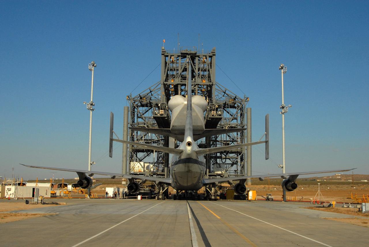 CAPE CANAVERAL, Fla. – At Edwards Air Force Base in California, space shuttle Atlantis is lowered from the mate/demate device toward the Shuttle Carrier Aircraft, or SCA, a modified Boeing 747, beneath it. Atlantis will be bolted to the SCA for a piggyback flight to Florida. A tail cone, which protects the aft engine area and provides a more efficient aeronautical dimension during its piggyback flight, can be seen. Atlantis landed at Edwards on May 24, which concluded mission STS-125, after two landing opportunities at Kennedy were waved off due to weather concerns. Atlantis is being returned to Florida on a ferry flight on the SCA. Atlantis' next assignment is the STS-129 mission, targeted to launch in November 2009. Photo credit: NASA/Ben Smegelsky