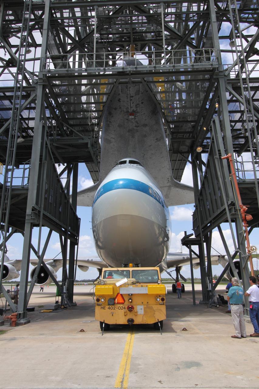 CAPE CANAVERAL, Fla. – On the Shuttle Landing Facility at NASA's Kennedy Space Center in Florida, the Shuttle Carrier Aircraft, or SCA, is moved from underneath space shuttle Atlantis in the mate/demate device. A hoist attached to Atlantis suspends the shuttle while the SCA is moved away. Atlantis returned from California atop the SCA, a modified Boeing 747, after its May 24 landing at Edwards Air Force Base, concluding mission STS-125. The ferry flight from Edwards Air Force Base began June 1. Atlantis' next assignment is the STS-129 mission, targeted to launch in November 2009. Photo credit: NASA/Jack Pfaller