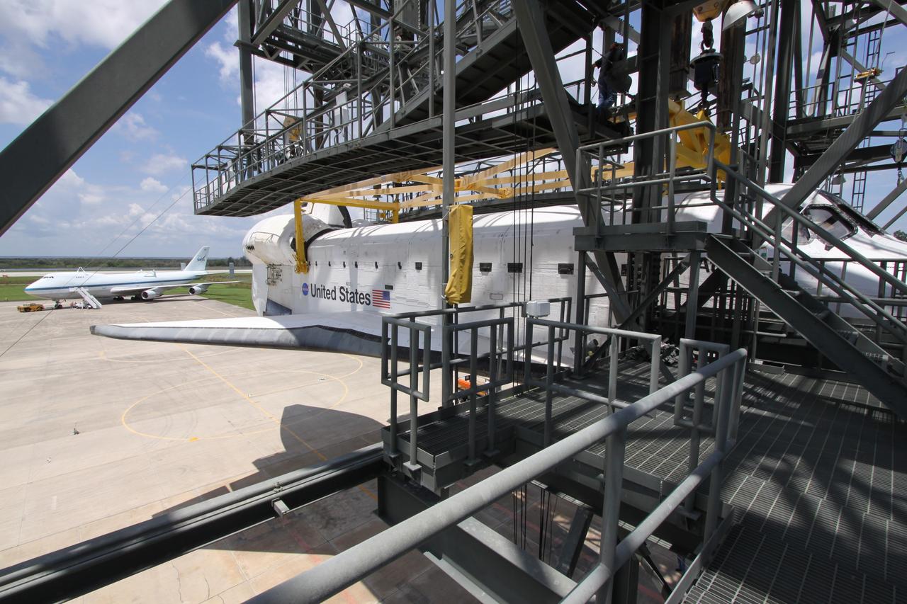 CAPE CANAVERAL, Fla. –  On the Shuttle Landing Facility at NASA's Kennedy Space Center in Florida, space shuttle Atlantis is lowered toward the ground after being demated from the Shuttle Carrier Aircraft seen at left.  Atlantis' wheels still must be lowered.  Atlantis returned from California atop the SCA, a modified Boeing 747, after its May 24 landing at Edwards Air Force Base, concluding mission STS-125. The ferry flight from Edwards Air Force Base began June 1. Atlantis' next assignment is the STS-129 mission, targeted to launch in November 2009.  Photo credit: NASA/Jack Pfaller