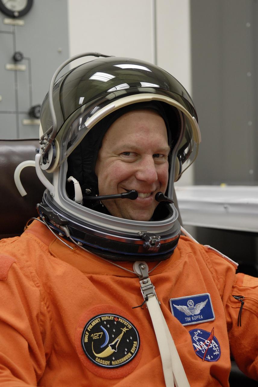 CAPE CANAVERAL, Fla. –  In the Operations and Checkout Building at NASA's Kennedy Space Center in Florida, STS-127 Mission Specialist Tim Kopra puts on the helmet for his launch-and-entry suit. He and other crew members will be heading for Launch Pad 39A for a simulated launch countdown. The crew is at Kennedy for a launch dress rehearsal called the terminal countdown demonstration test, or TCDT, which includes emergency exit training and equipment familiarization.  Endeavour's STS-127 mission is the final of three flights dedicated to the assembly of the Japanese Kibo laboratory complex on the International Space Station.  Endeavour's launch is scheduled for June 13 at 7:17 a.m. EDT.  Photo credit: NASA/Kim Shiflett