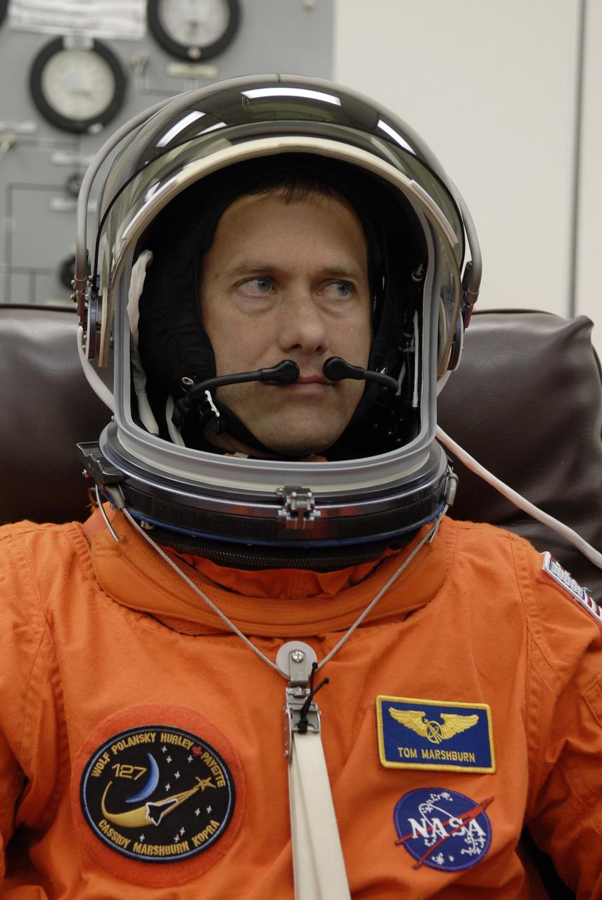 CAPE CANAVERAL, Fla. –  In the Operations and Checkout Building at NASA's Kennedy Space Center in Florida, STS-127 Mission Specialist Tom Marshburn checks the communication system in his helmet. He and other crew members will be heading for Launch Pad 39A for a simulated launch countdown.  The crew is at Kennedy for a launch dress rehearsal called the terminal countdown demonstration test, or TCDT, which includes emergency exit training and equipment familiarization.  Endeavour's STS-127 mission is the final of three flights dedicated to the assembly of the Japanese Kibo laboratory complex on the International Space Station.  Endeavour's launch is scheduled for June 13 at 7:17 a.m. EDT.  Photo credit: NASA/Kim Shiflett