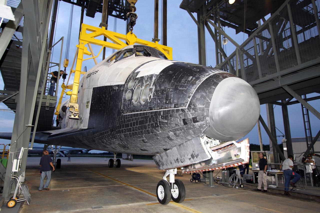 CAPE CANAVERAL, Fla. – Space shuttle Atlantis is on the ground at the Shuttle Landing Facility at NASA's Kennedy Space Center in Florida. Workers prepare to remove the hoist from Atlantis that was used to separate it from the Shuttle Carrier Aircraft, or SCA, which returned it to Kennedy from California. Atlantis will be towed to Orbiter Processing Facility 1. After its May 24 landing at Edwards Air Force Base in California, which concluded its STS-125 mission, the modified Boeing 747 SCA carried the shuttle on a two-day ferry flight from Edwards to Kennedy beginning June 1. Atlantis' next assignment is the STS-129 mission, targeted to launch in November 2009. Photo credit: NASA/Jack Pfaller