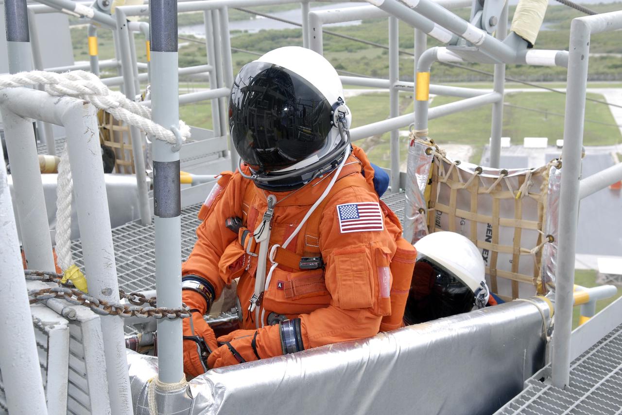 CAPE CANAVERAL, Fla. – On Launch Pad 39A at NASA's Kennedy Space Center in Florida, STS-127 Commander Mark Polansky and Pilot Doug Hurley get seated in the slidewire basket as they practice emergency exit procedures that are part of the terminal countdown demonstration test, which concluded with a simulated launch countdown.  Endeavour's STS-127 mission is the final of three flights dedicated to the assembly of the Japanese Kibo laboratory complex on the International Space Station.  Endeavour's launch is scheduled for June 13 at 7:17 a.m. EDT.   Photo credit: NASA/Kim Shiflett