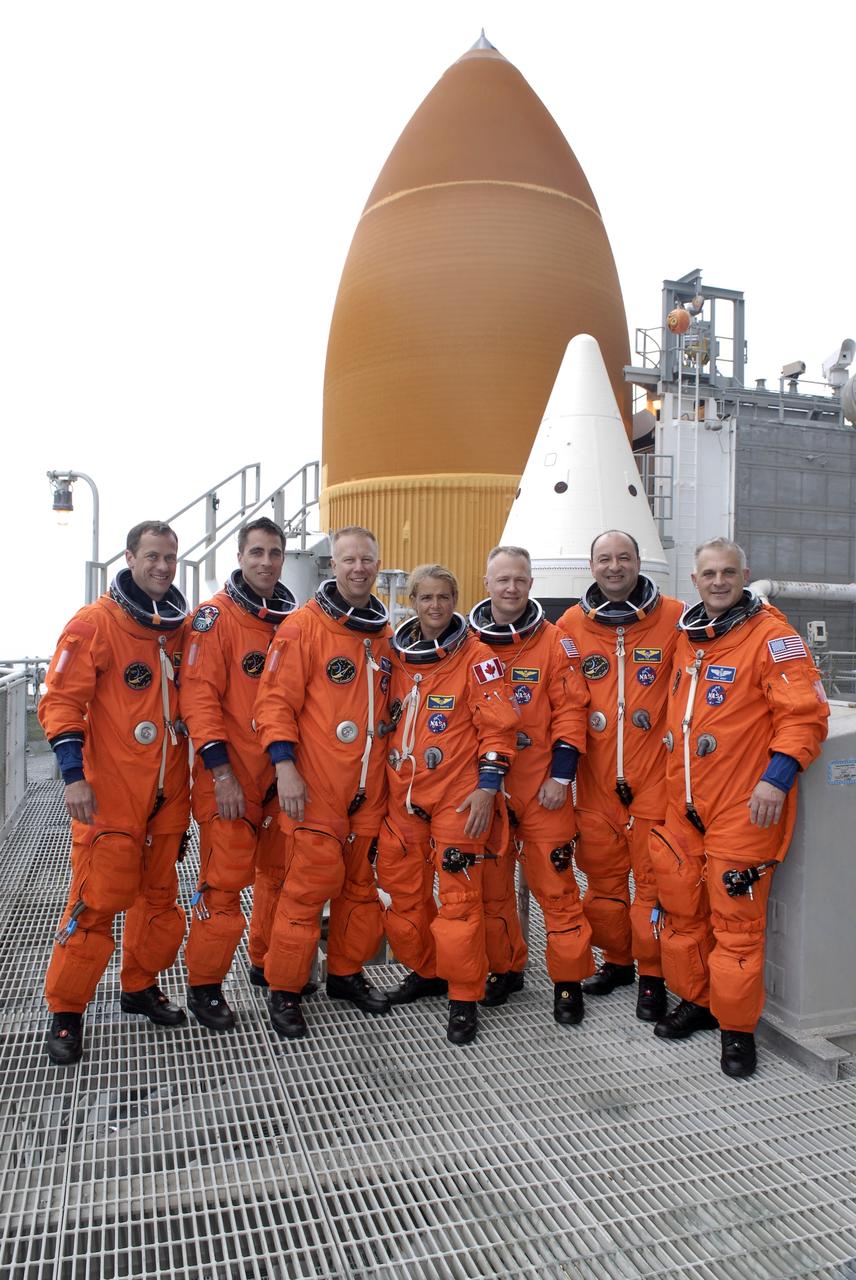 CAPE CANAVERAL, Fla. – The STS-127 crew members gather at the 225-foot level of the fixed service structure for a photo to commemorate the conclusion of the terminal countdown demonstration test, which ended with a simulated launch countdown.  From left are Mission Specialists Tom Marshburn, Christopher Cassidy, Tim Kopra and Julie Payette, Pilot Doug Hurley, Commander Mark Polansky and Mission Specialist Dave Wolf. Behind them are the tops of the orange external fuel tank and one of the two solid rocket boosters. Endeavour's STS-127 mission is the final of three flights dedicated to the assembly of the Japanese Kibo laboratory complex on the International Space Station.  Endeavour's launch is scheduled for June 13 at 7:17 a.m. EDT.   Photo credit: NASA/Kim Shiflett