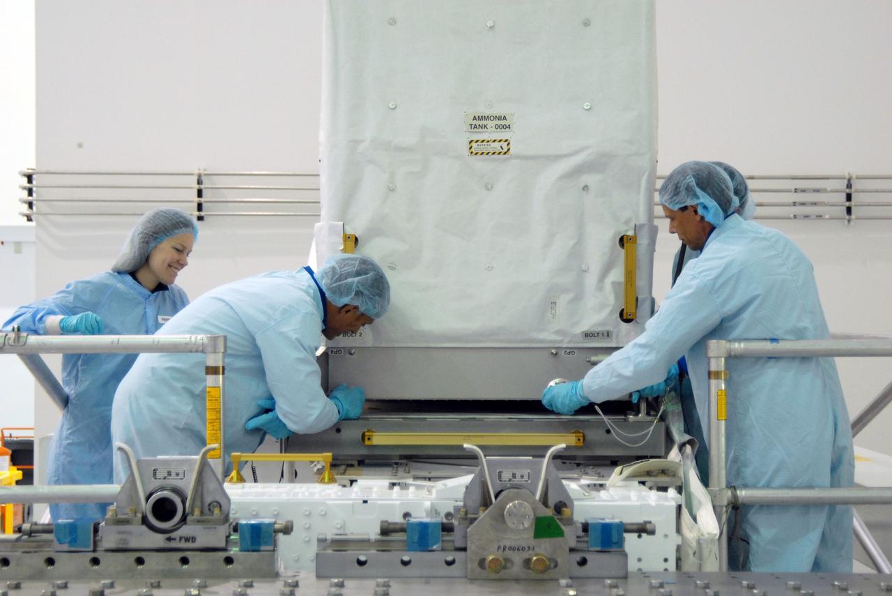 CAPE CANAVERAL, Fla. – In the Space Station Processing Facility at NASA's Kennedy Space Center in Florida, STS-128 Mission Specialists John "Danny" Olivas (second from left) and Christer Fugelsang (right) inspect ammonia tanks, part of the payload for their mission.  Fugelsang is with the European Space Agency.   Members of the STS-128 crew are at Kennedy for a crew equipment interface test, or CEIT, which provides hands-on training and observation of shuttle and flight hardware. The STS-128 flight will carry science and storage racks to the International Space Station on space shuttle Discovery. The STS-128 mission is targeted to launch on Aug. 6. Photo credit: NASA/Jim Grossmann