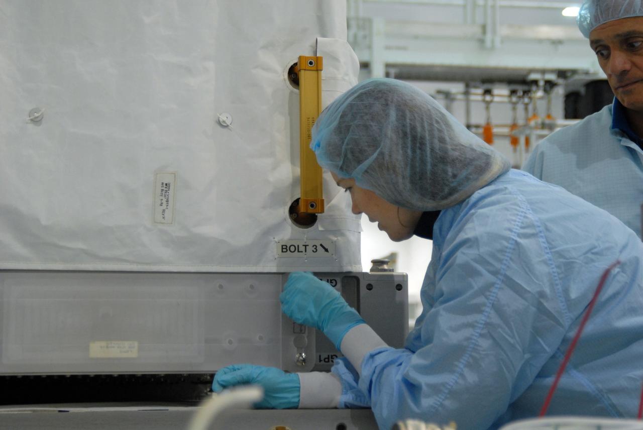 CAPE CANAVERAL, Fla. – In the Space Station Processing Facility at NASA's Kennedy Space Center in Florida, a worker demonstrates an attachment point on ammonia tanks while STS-128 Mission Specialist John "Danny" Olivas (far right) looks on. The tanks are part of the payload for their upcoming STS-128 mission. Members of the STS-128 crew are at Kennedy for a crew equipment interface test, or CEIT, which provides hands-on training and observation of shuttle and flight hardware. The STS-128 flight will carry science and storage racks to the International Space Station on space shuttle Discovery. The STS-128 mission is targeted to launch on Aug. 6. Photo credit: NASA/Jim Grossmann