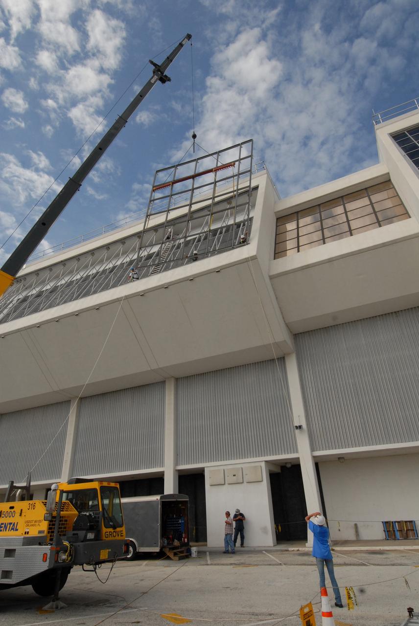 CAPE CANAVERAL, Fla. – At NASA's Kennedy Space Center in Florida, new, hurricane-rated window systems for the Launch Control Center's four Firing Rooms and the vestibule areas between Firing Rooms 1 & 2 and Firing Rooms 3 & 4 are being installed.  In order to avoid operational impacts, the new windows are being installed on the outside of the existing windows, enclosing the space formerly occupied by the louvers, and the old windows will remain in place until the new windows are completely installed and leak tested. This approach will continue to keep the firing rooms from being exposed to the elements.  Photo credit: NASA/Tim Jacobs