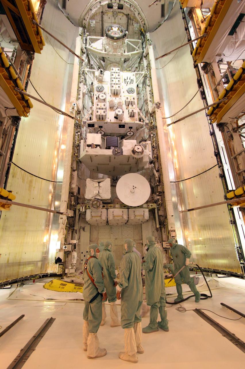 CAPE CANAVERAL, Fla. – On Launch Pad 39A at NASA's Kennedy Space Center in Florida, workers ensure smooth closure of space shuttle Endeavour's payload bay doors. Elements stored in the payload bay are, at bottom, the Integrated Cargo Carrier-Vertical Light Deploy (with the Space-to-Ground Antenna showing), the Experiment Logistics Module-Exposed Section (middle) and the Japanese Experiment Module's Exposed Facility (at top). The STS-127 mission is the final of three flights dedicated to the assembly of the Japanese Kibo laboratory complex on the International Space Station. Photo credit: NASA/Jack Pfaller