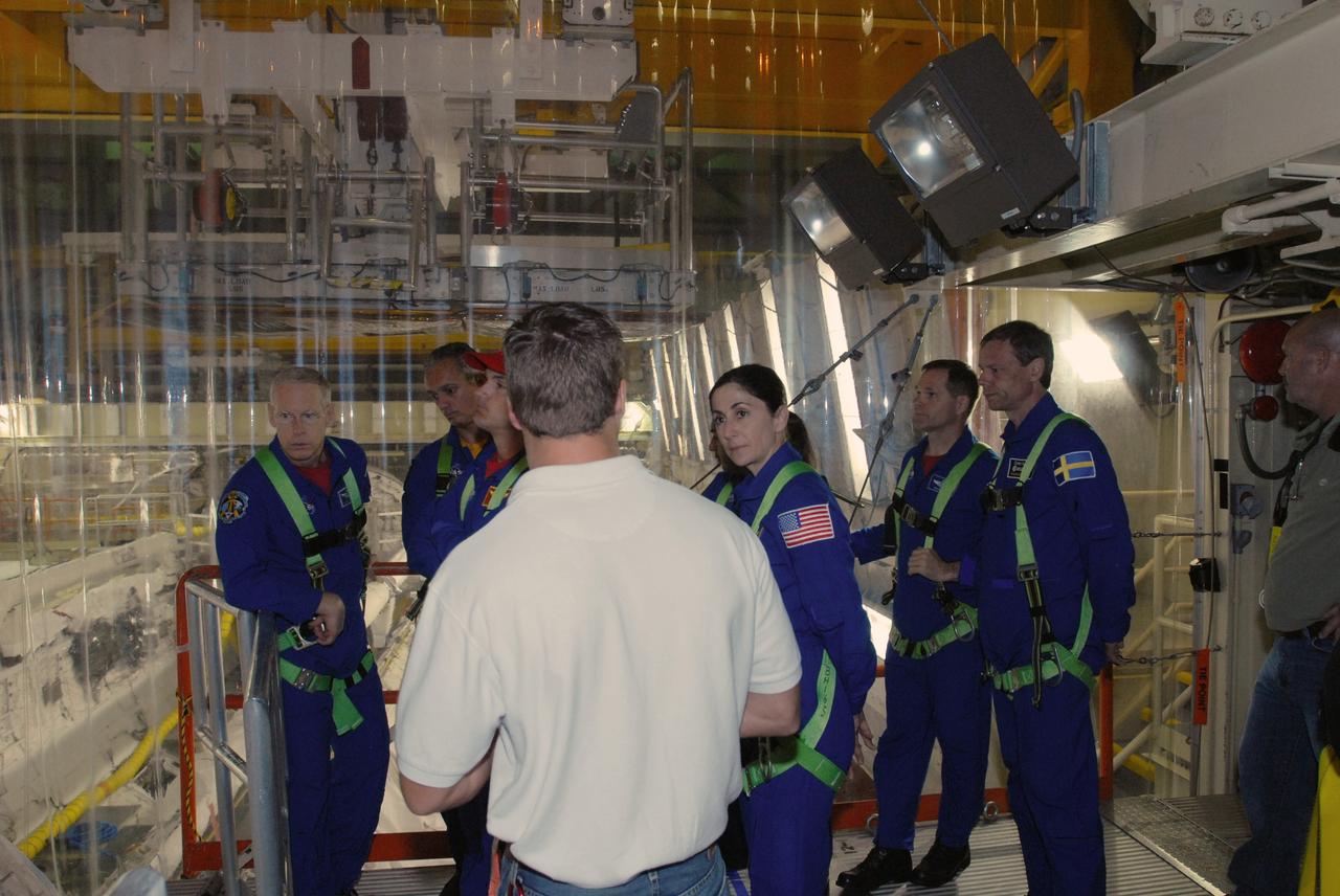 CAPE CANAVERAL, Fla. – Wearing harnesses, STS-128 crew members check out space shuttle Discovery in Orbiter Processing Facility 3 at NASA's Kennedy Space Center in Florida. From left are Mission Specialists Patrick Forrester and John "Danny" Olivas, Commander Rick Sturckow, Mission Specialist Nicole Stott, Pilot Kevin Ford and Mission Specialist Christer Fuglesang. The crew is at Kennedy for a crew equipment interface test, or CEIT, which provides hands-on training and observation of shuttle and flight hardware. The STS-128 flight will carry science and storage racks to the International Space Station on Discovery.  Launch is targeted for Aug. 7.   Photo credit: NASA/Jim Grossmann