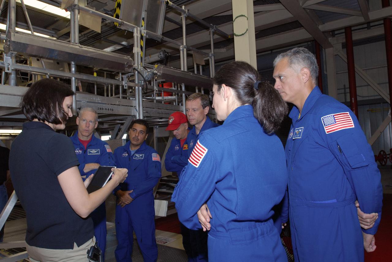 CAPE CANAVERAL, Fla. – In Orbiter Processing Facility 3 at NASA's Kennedy Space Center in Florida, STS-128 crew members listen to a tile specialist while checking out space shuttle Discovery.  The astronauts are, from left, Mission Specialists Patrick Forrester and Jose Hernandez, Commander Rick Sturckow, and Mission Specialist Christer Fuglesang, Nicole Stott and John "Danny" Olivas.  The crew is at Kennedy for a crew equipment interface test, or CEIT, which provides hands-on training and observation of shuttle and flight hardware. The STS-128 flight will carry science and storage racks to the International Space Station on Discovery.  Launch is targeted for Aug. 7.   Photo credit: NASA/Jim Grossmann