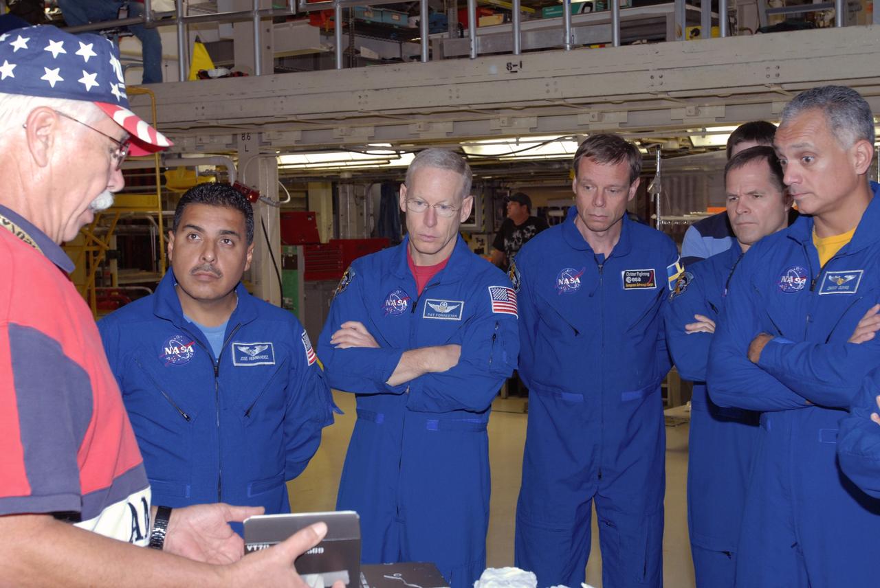 CAPE CANAVERAL, Fla. – In Orbiter Processing Facility 3 at NASA's Kennedy Space Center in Florida, STS-128 crew members listen to a tile expert while checking out space shuttle Discovery.   The astronauts are, from left, Mission Specialists Jose Fernandez, Patrick Forrester and Christer Fuglesang, Pilot Kevin Ford and Mission Specialist John "Danny" Olivas. The crew is at Kennedy for a crew equipment interface test, or CEIT, which provides hands-on training and observation of shuttle and flight hardware. The STS-128 flight will carry science and storage racks to the International Space Station on Discovery.  Launch is targeted for Aug. 7.   Photo credit: NASA/Jim Grossmann
