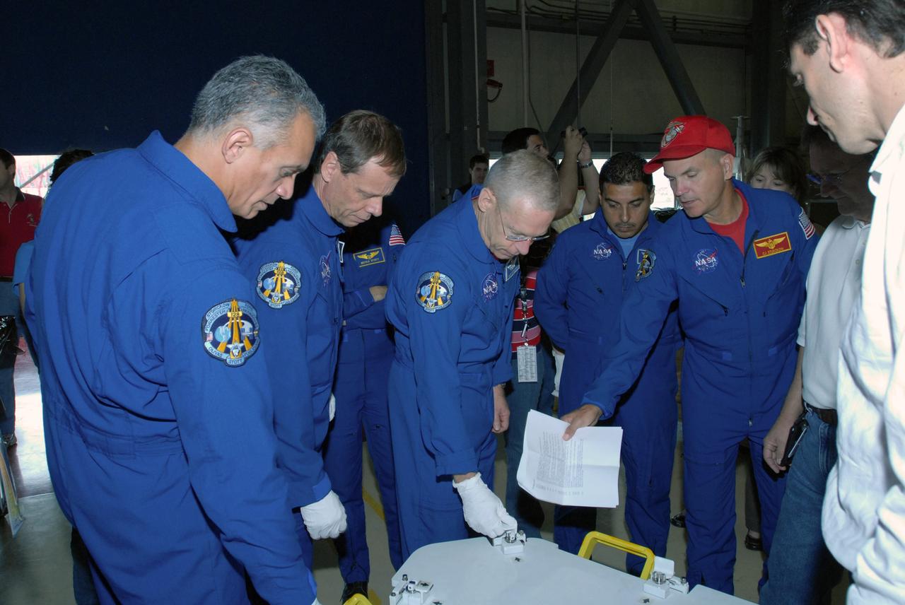 CAPE CANAVERAL, Fla. – In Orbiter Processing Facility 3 at NASA's Kennedy Space Center in Florida, STS-128 crew members check out storage containers they will use on the mission.  From left are Mission Specialists John "Danny" Olivas, Christer Fuglesang, Patrick Forrester and Jose Hernandez, and Commander Rick Sturckow (pointing).  The crew is at Kennedy for a crew equipment interface test, or CEIT, which provides hands-on training and observation of shuttle and flight hardware. The STS-128 flight will carry science and storage racks to the International Space Station on Discovery.  Launch is targeted for Aug. 7.   Photo credit: NASA/Jim Grossmann