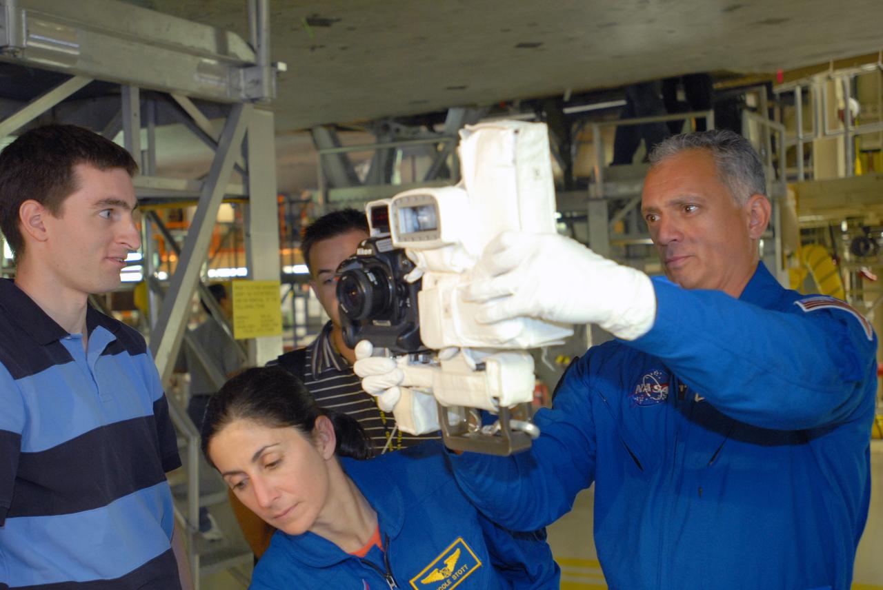 CAPE CANAVERAL, Fla. – In Orbiter Processing Facility 3 at NASA's Kennedy Space Center in Florida, STS-128 Mission Specialists Nicole Stott and John "Danny" Olivas practice with a camera they will use on their upcoming STS-128 mission.  The crew is at Kennedy for a crew equipment interface test, or CEIT, which provides hands-on training and observation of shuttle and flight hardware. The STS-128 flight will carry science and storage racks to the International Space Station on Discovery.  Launch is targeted for Aug. 7.   Photo credit: NASA/Jim Grossmann