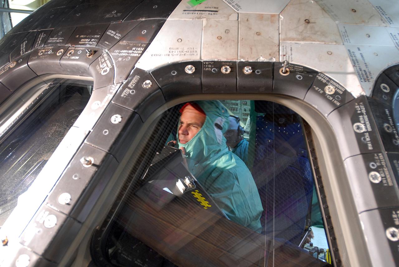 CAPE CANAVERAL, Fla. – In Orbiter Processing Facility 3 at NASA's Kennedy Space Center in Florida, STS-128 mission Commander Rick Sturckow checks out the cockpit window of space shuttle Discovery.  The crew is at Kennedy for a crew equipment interface test, or CEIT, which provides hands-on training and observation of shuttle and flight hardware. The STS-128 flight will carry science and storage racks to the International Space Station on Discovery.  Launch is targeted for Aug. 7.   Photo credit: NASA/Jim Grossmann