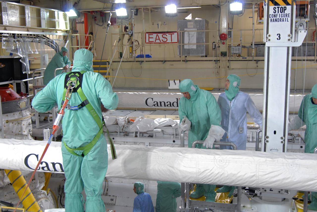CAPE CANAVERAL, Fla. – TIn Orbiter Processing Facility 3 at NASA's Kennedy Space Center in Florida, STS-128 crew members are lowered into space shuttle Discovery's payload bay to check equipment. At center is Mission Specialist John "Danny" Olivas.  The crew is at Kennedy for a crew equipment interface test, or CEIT, which provides hands-on training and observation of shuttle and flight hardware. The STS-128 flight will carry science and storage racks to the International Space Station on Discovery.  Launch is targeted for Aug. 7.   Photo credit: NASA/Jim Grossmann