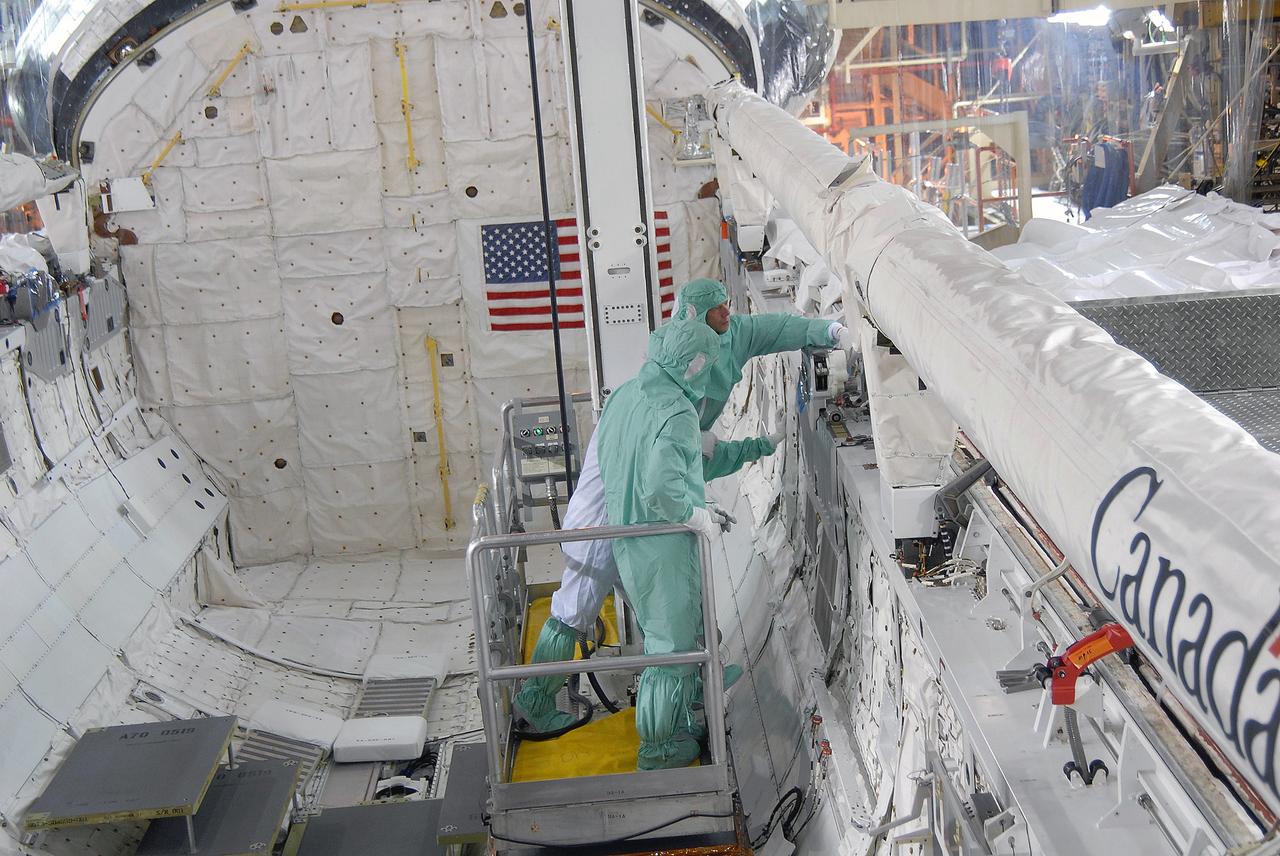 CAPE CANAVERAL, Fla. – In Orbiter Processing Facility 3 at NASA's Kennedy Space Center in Florida, STS-128 crew members check out the space shuttle Discovery's robotic arm.  Reaching toward the arm is Mission Specialist Christer Fuglesang. The crew is at Kennedy for a crew equipment interface test, or CEIT, which provides hands-on training and observation of shuttle and flight hardware. The STS-128 flight will carry science and storage racks to the International Space Station on Discovery.  Launch is targeted for Aug. 7.   Photo credit: NASA/Jim Grossmann