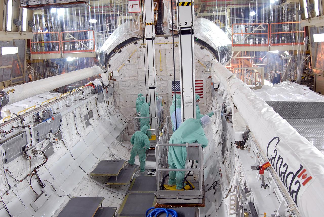CAPE CANAVERAL, Fla. – In Orbiter Processing Facility 3 at NASA's Kennedy Space Center in Florida, STS-128 crew members are lowered into space shuttle Discovery's payload bay to get a close look at equipment.  The crew is at Kennedy for a crew equipment interface test, or CEIT, which provides hands-on training and observation of shuttle and flight hardware. The STS-128 flight will carry science and storage racks to the International Space Station on Discovery.  Launch is targeted for Aug. 7.   Photo credit: NASA/Jim Grossmann