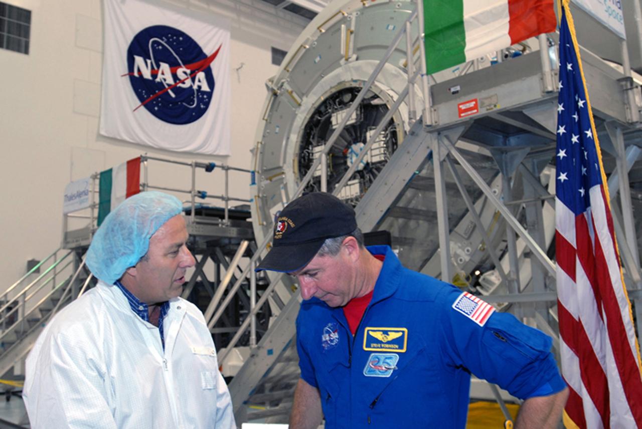 CAPE CANAVERAL, Fla. – During a media event in the Space Station Processing Facility at NASA's Kennedy Space Center in Florida to showcase the newest section of the International Space Station, the Tranquility node, astronaut Stephen Robinson talks with Giuseppe Mancuso from Thales Alenia Space Italy.  Robinson is a mission specialist on the STS-130 mission that will deliver Tranquility to the space station. Managers from NASA, the European Space Agency, Thales Alenia Space and Boeing -- the organizations involved in building and processing the module for flight -- were available for a question-and-answer session during the event.  Tranquility is a pressurized module that will provide room for many of the station's life support systems.  Photo credit: NASA/Jim Grossmann