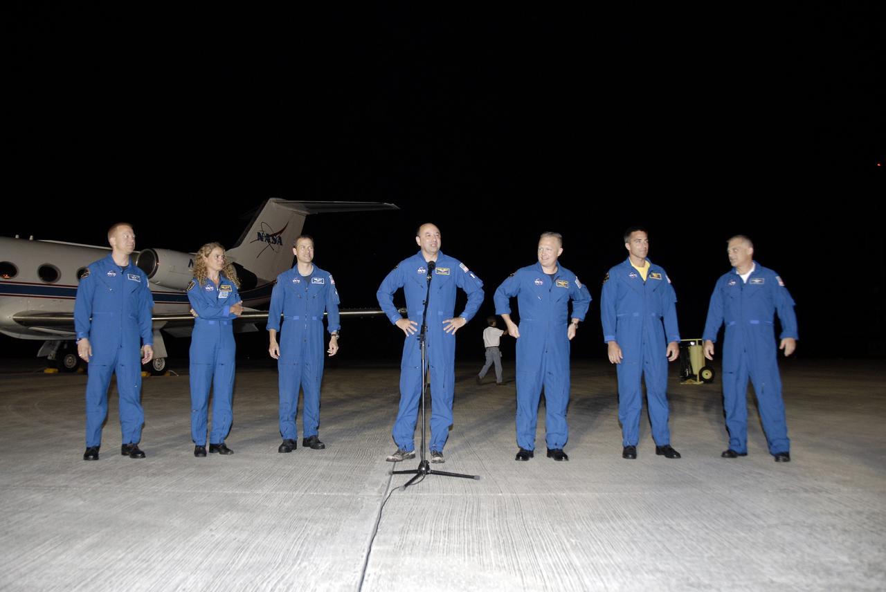 CAPE CANAVERAL, Fla. – At the Shuttle Landing Facility, STS-127 Commander Mark Polansky, at microphone, addresses the media and those on hand to welcome the STS-127 crew to NASA's Kennedy Space Center in Florida. Polansky and the other members of the crew arrived from Houston aboard the Shuttle Training Aircraft in the background to get ready for launch on space shuttle Endeavour on June 13.  From left are Mission Specialists Tim Kopra, Julie Payette of the Canadian Space Agency, and Tom Marshburn; Commander Mark Polansky; Pilot Doug Hurley; and Mission Specialists Christopher Cassidy and Dave Wolf. The STS-127 mission is the final of three flights dedicated to the assembly of the Japan Aerospace Exploration Agency's Kibo laboratory complex on the International Space Station.  Endeavour will deliver the Japanese Experiment Module's Exposed Facility, or JEM-EF, and the Experiment Logistics Module-Exposed Section, or ELM-ES, to the space station on STS-127.  Photo credit: NASA/Kim Shiflett